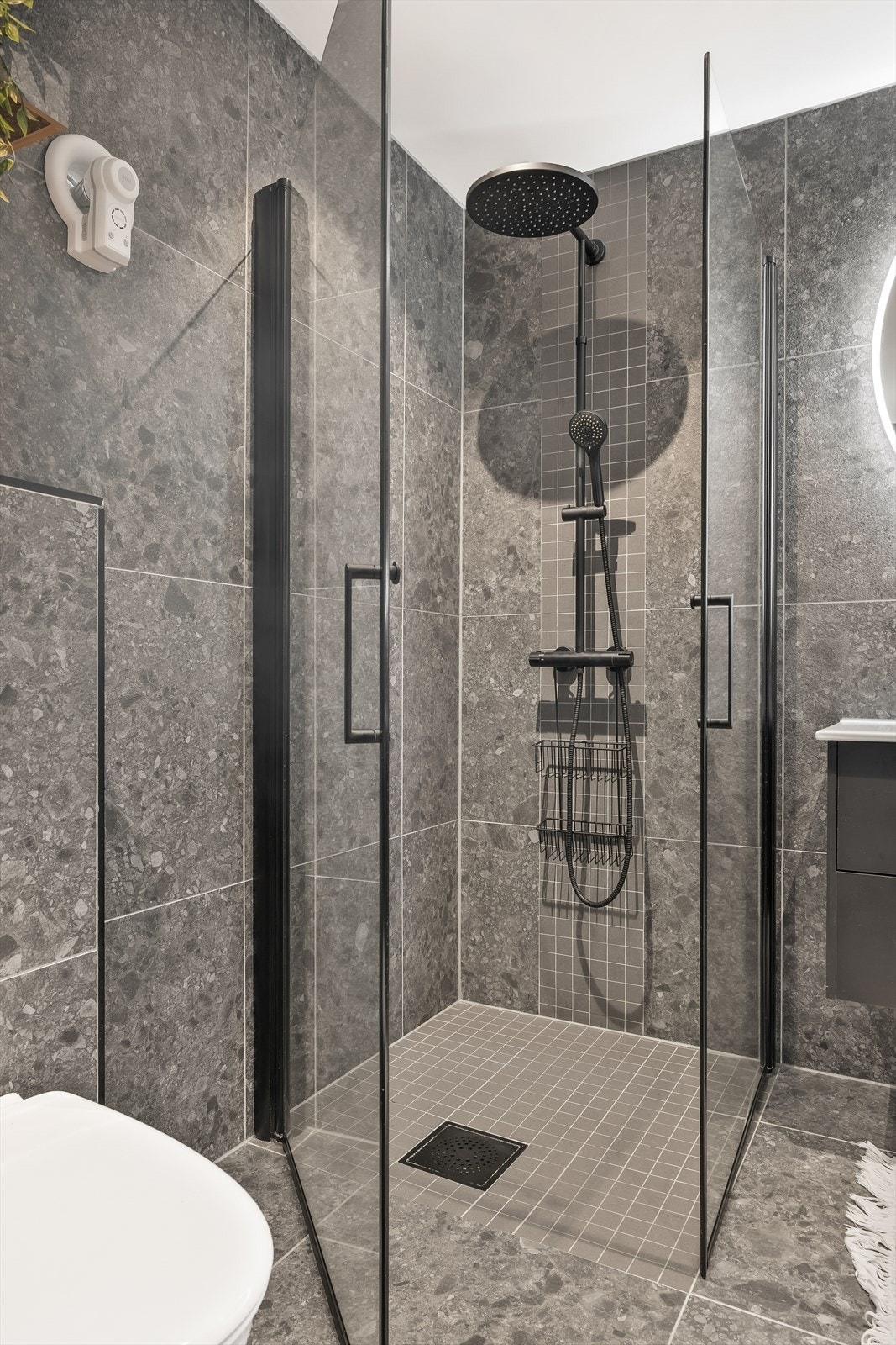 Dusjhjørne med innfellbare glassdører og sorte detaljer på armaturer. Galleribilde