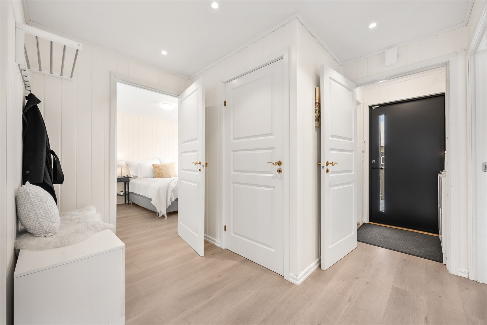 Velkommen inn i en lys entré med en-stavs laminatgulv som går igjen i store deler av etasjen. Galleribilde