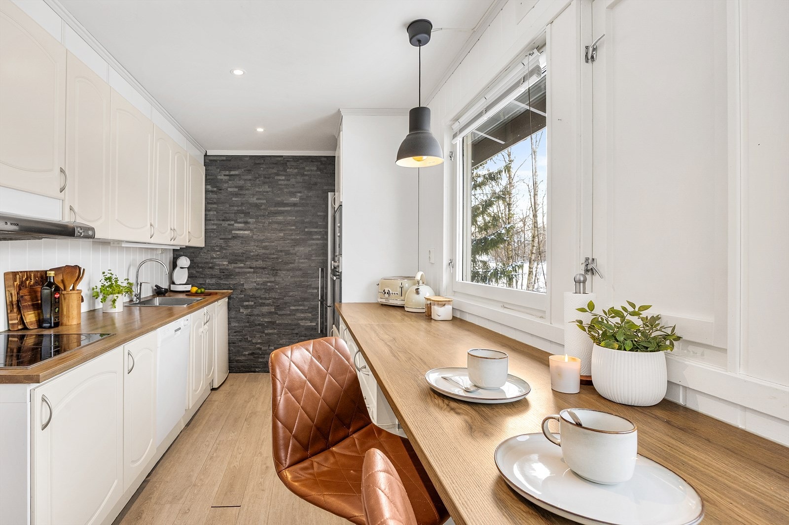 En praktisk barløsning langs vinduet gir en hyggelig spiseplass for raske måltider. Galleribilde