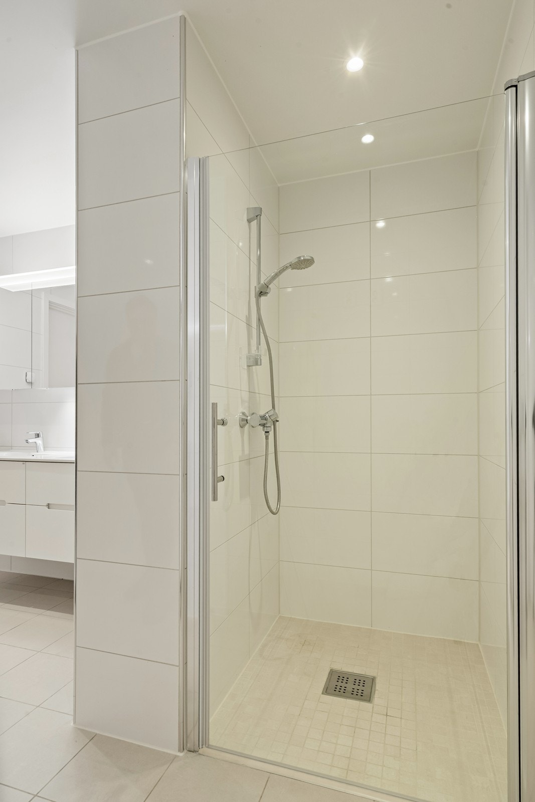 Badet har et praktisk dusjhjørne med innfellbare glassdører og opplegg for vaskemaskin. Galleribilde