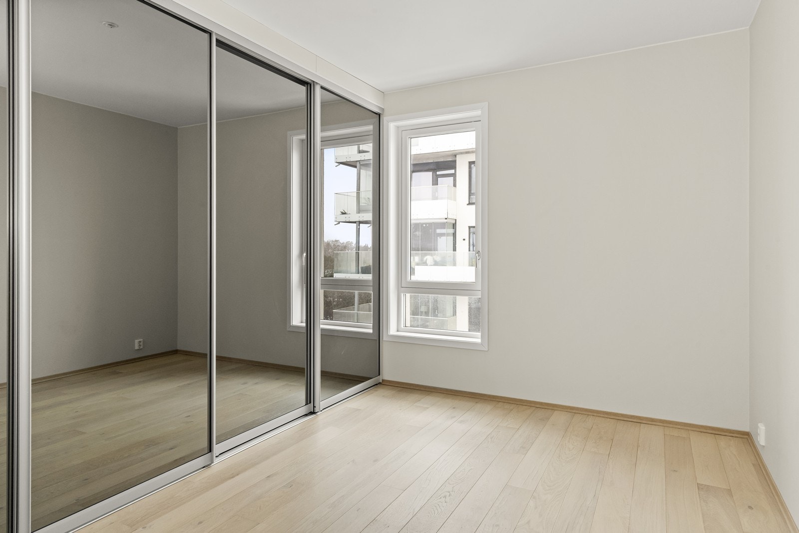 En stor skyvedørsgarderobe med speilfronter gir rikelig med oppbevaringsplass. Galleribilde