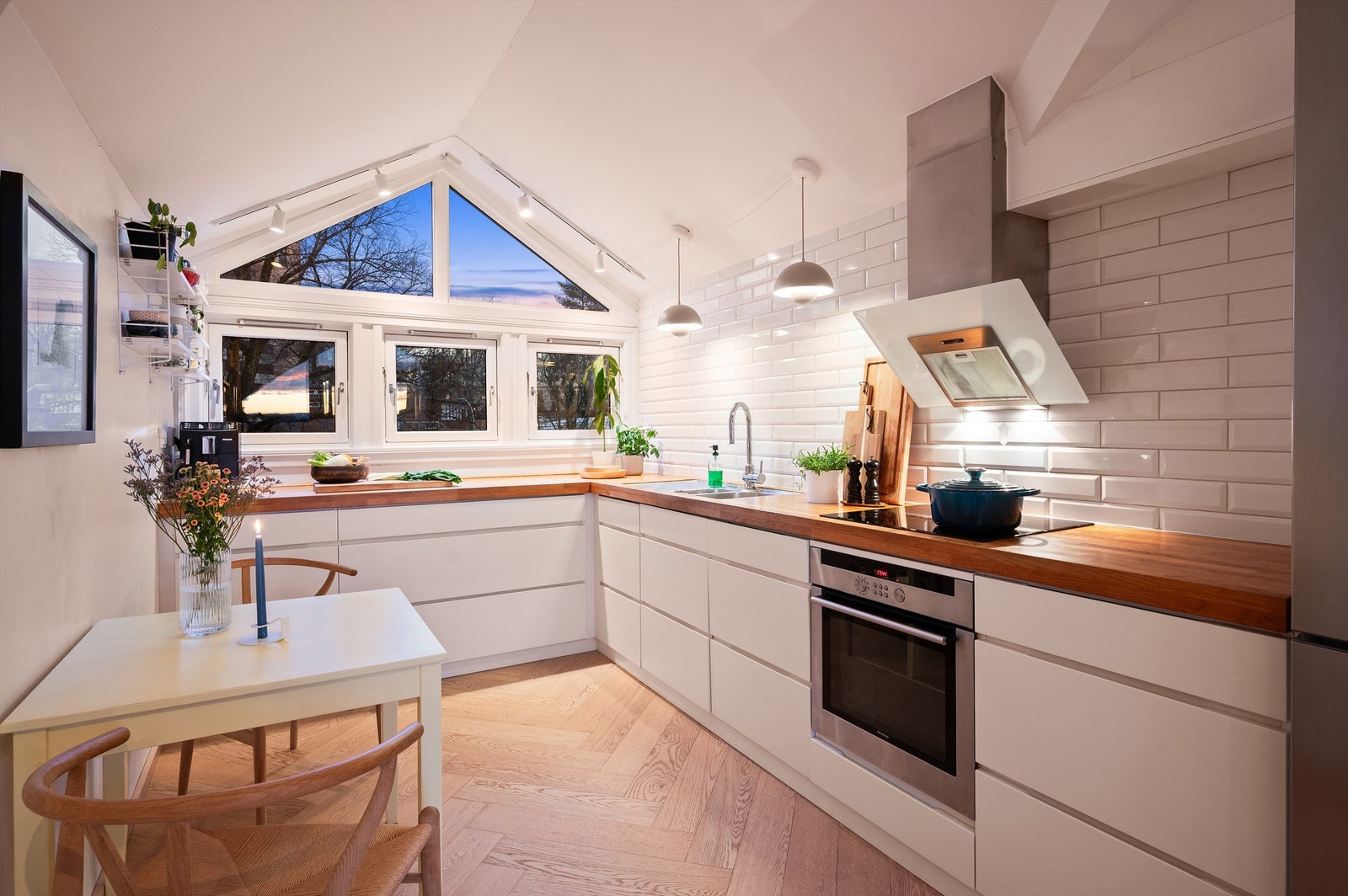 Et lyst og funksjonelt kjøkken med god arbeidsflyt og plass til en liten spiseplass. Galleribilde