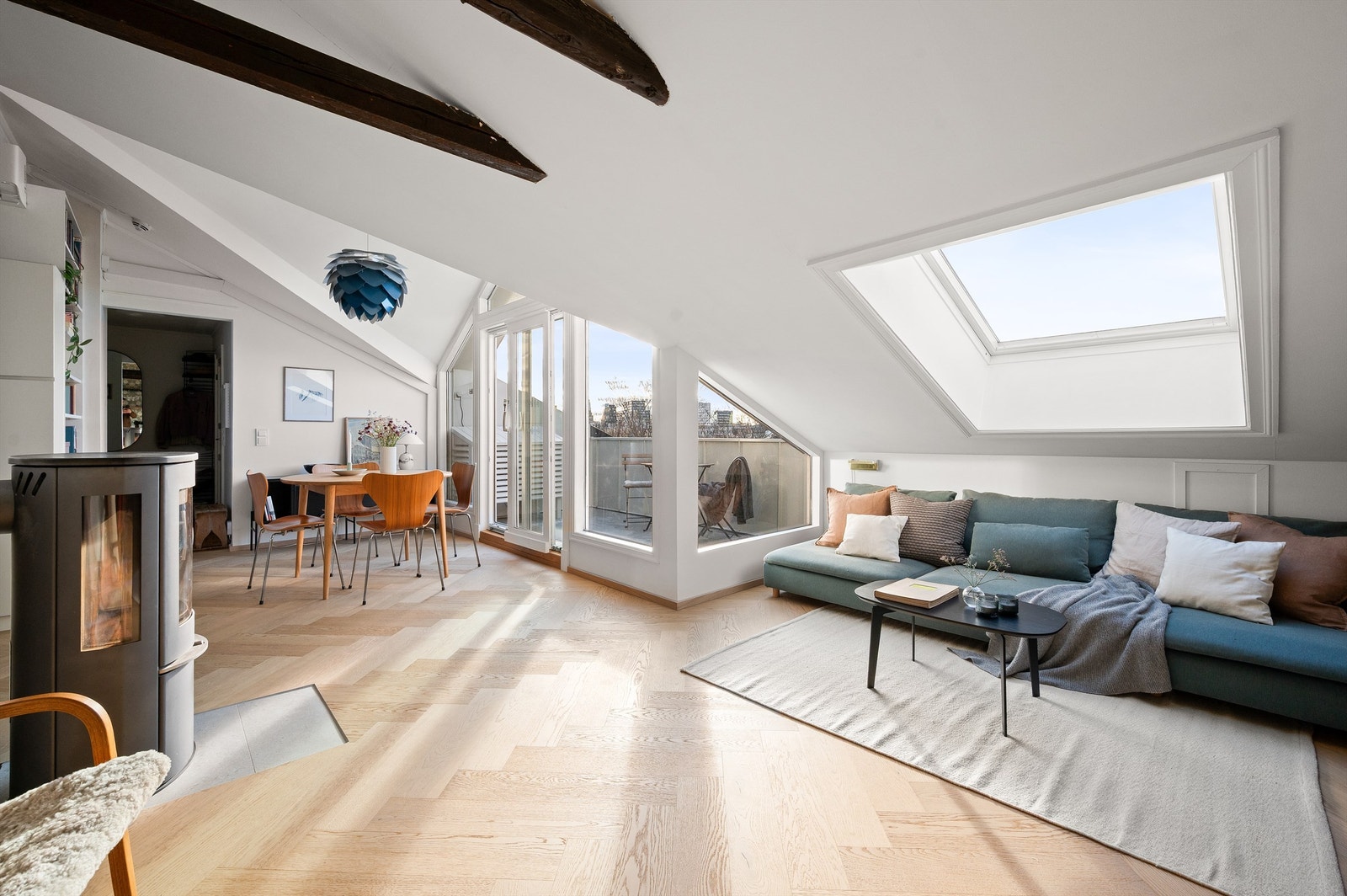 Store vindusflater og takvindu slipper inn rikelig med dagslys, supplert av en stemningsfull vedovn. Galleribilde