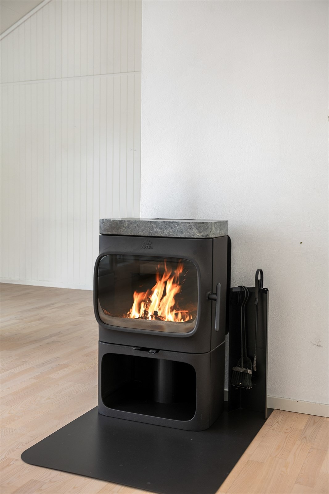 Et lukket ildsted ved en pusset elementpipe gir effektiv oppvarming og en hyggelig atmosfære. Galleribilde