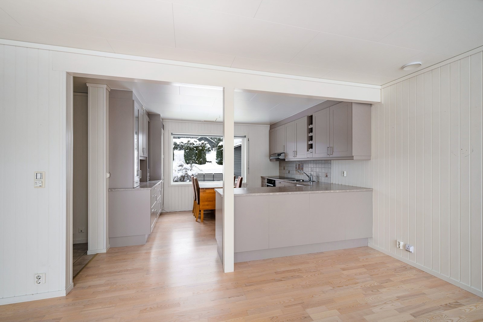 Kjøkkenet er praktisk utformet med en halvøy som gir ekstra benkeplass og en fin soneinndeling. Galleribilde