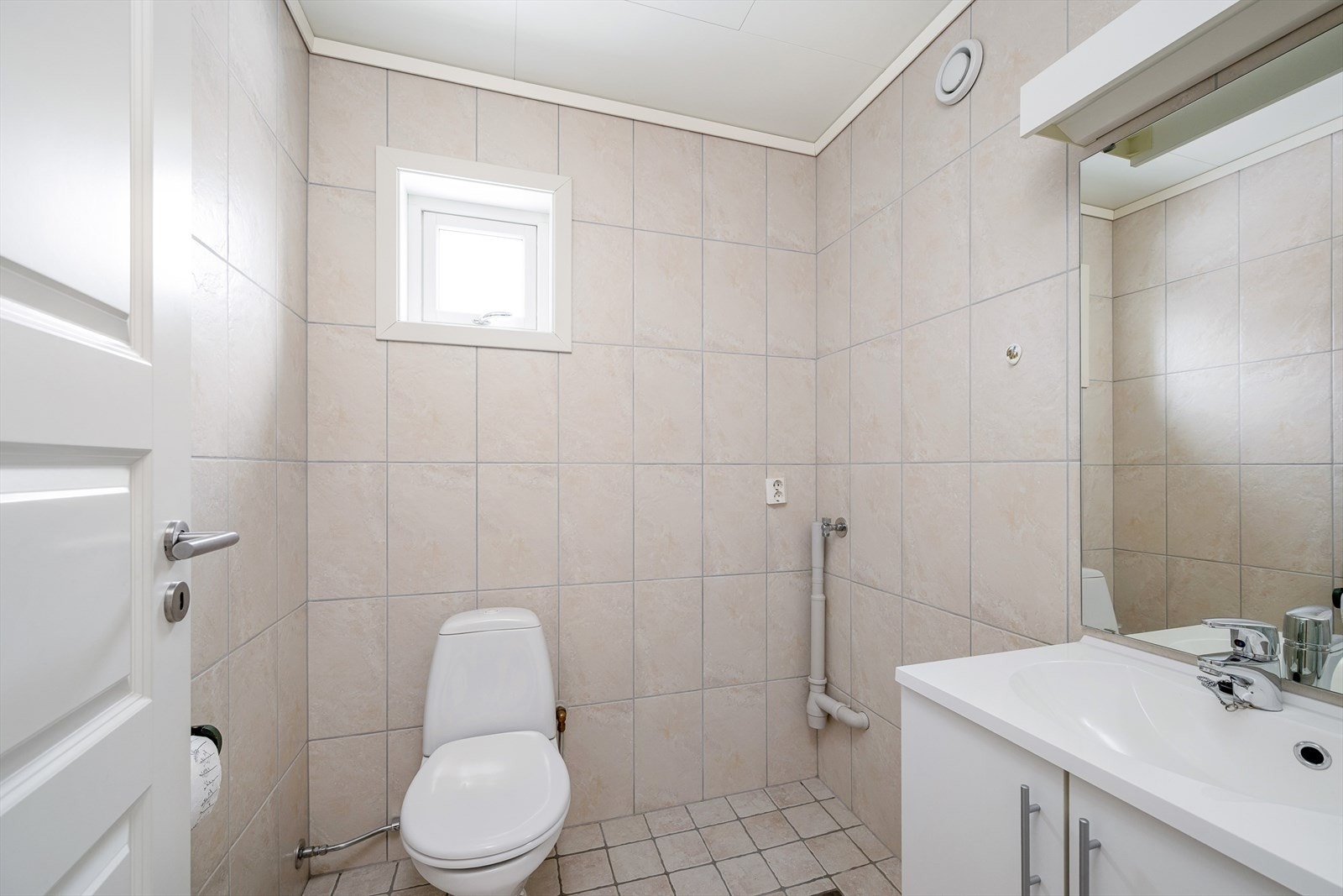 Praktisk bad i første etasje, utstyrt med toalett og flislagt gulv med varme. Galleribilde