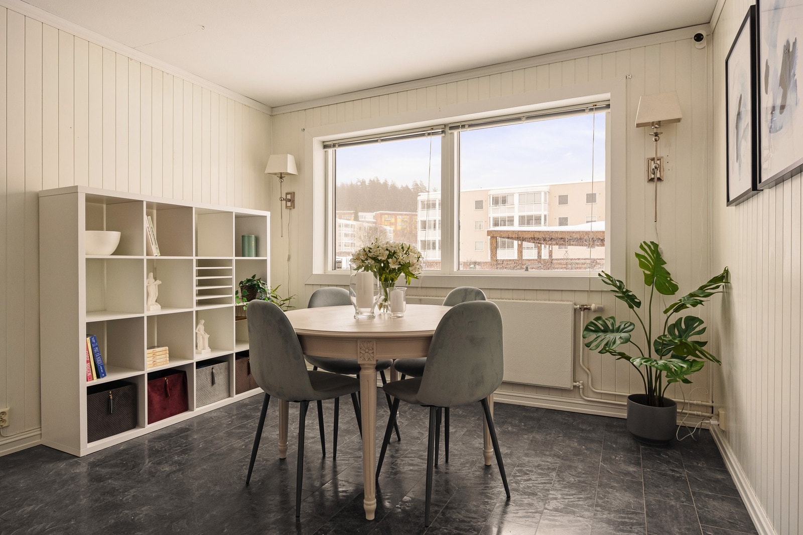 Laminat på gulv, panelplater på vegger og malt himling gir rommet en helhetlig og trivelig atmosfære som inviterer til både hverdagsmiddager og lange samtaler rundt kjøkkenbordet. Galleribilde