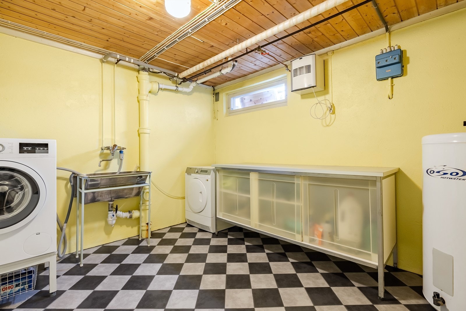 I kjelleren er det et praktisk vaskerom med flislagt gulv, innredning, utslagskum og opplegg for både vaskemaskin og tørketrommel. Galleribilde