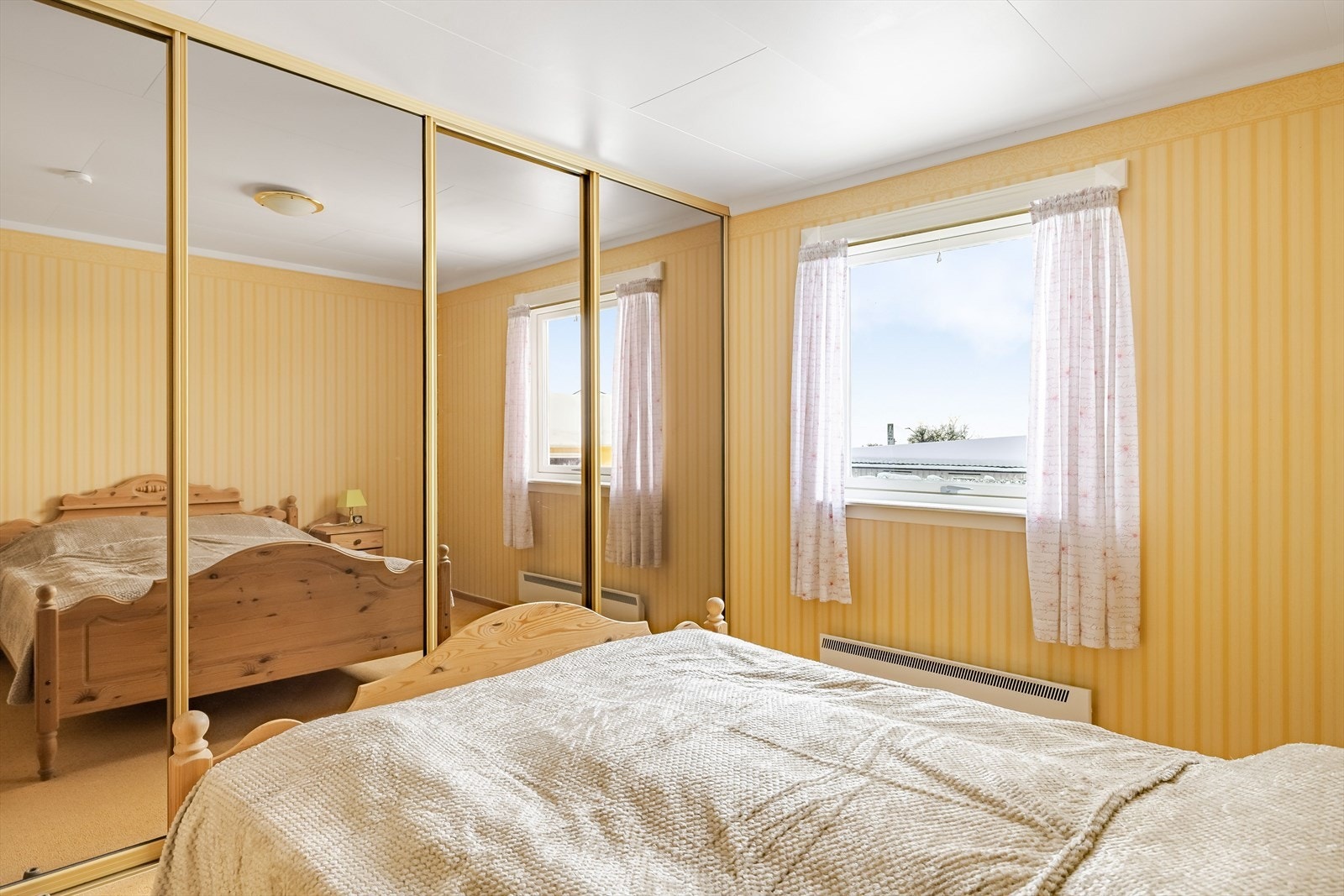 Det er rikelig med oppbevaringsplass i stor plassbygget skyvedørsgarderobe med speildører. Galleribilde