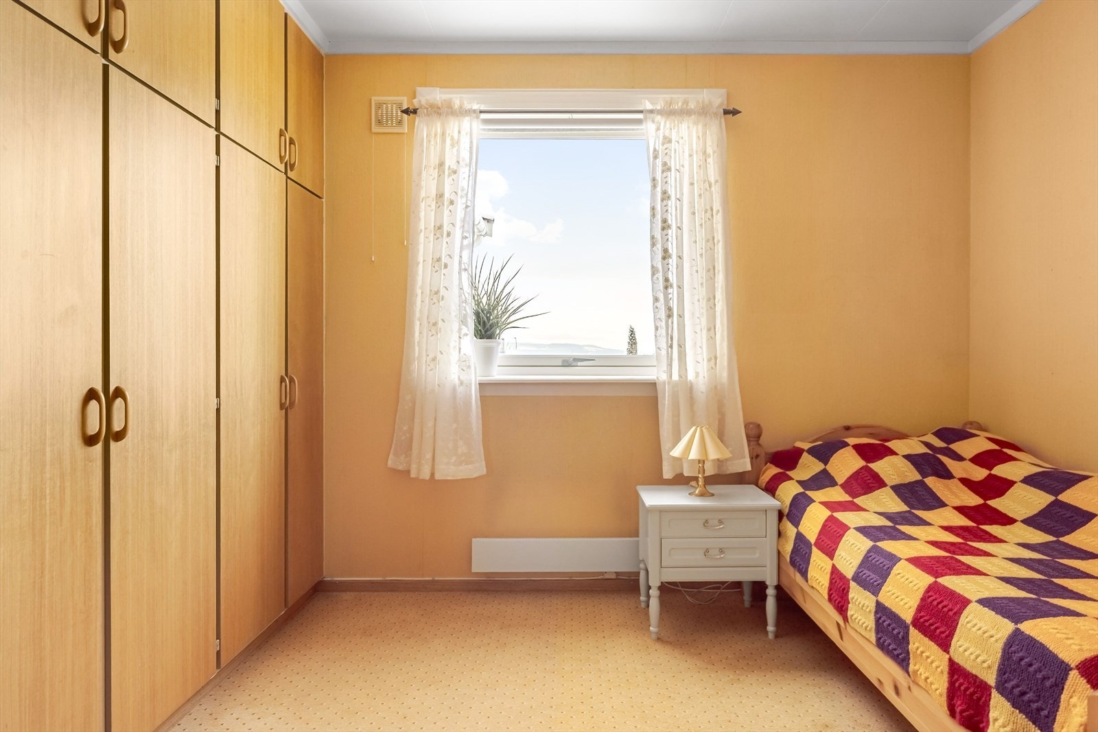 Soverommet har teppegulv, gulmalte overflater og vindu fra 2011. Galleribilde