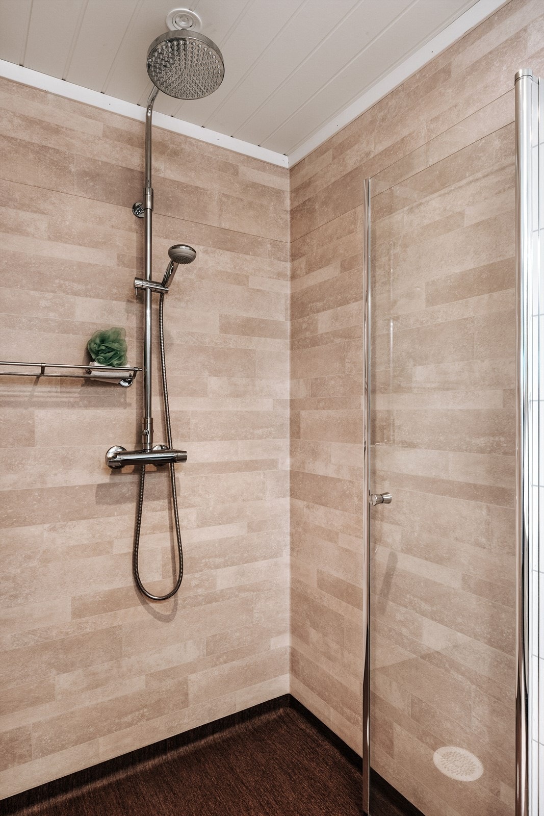 Romslig dusj med innfellbar dusjdør og veggmontert dujbatteri med regnfall. Galleribilde