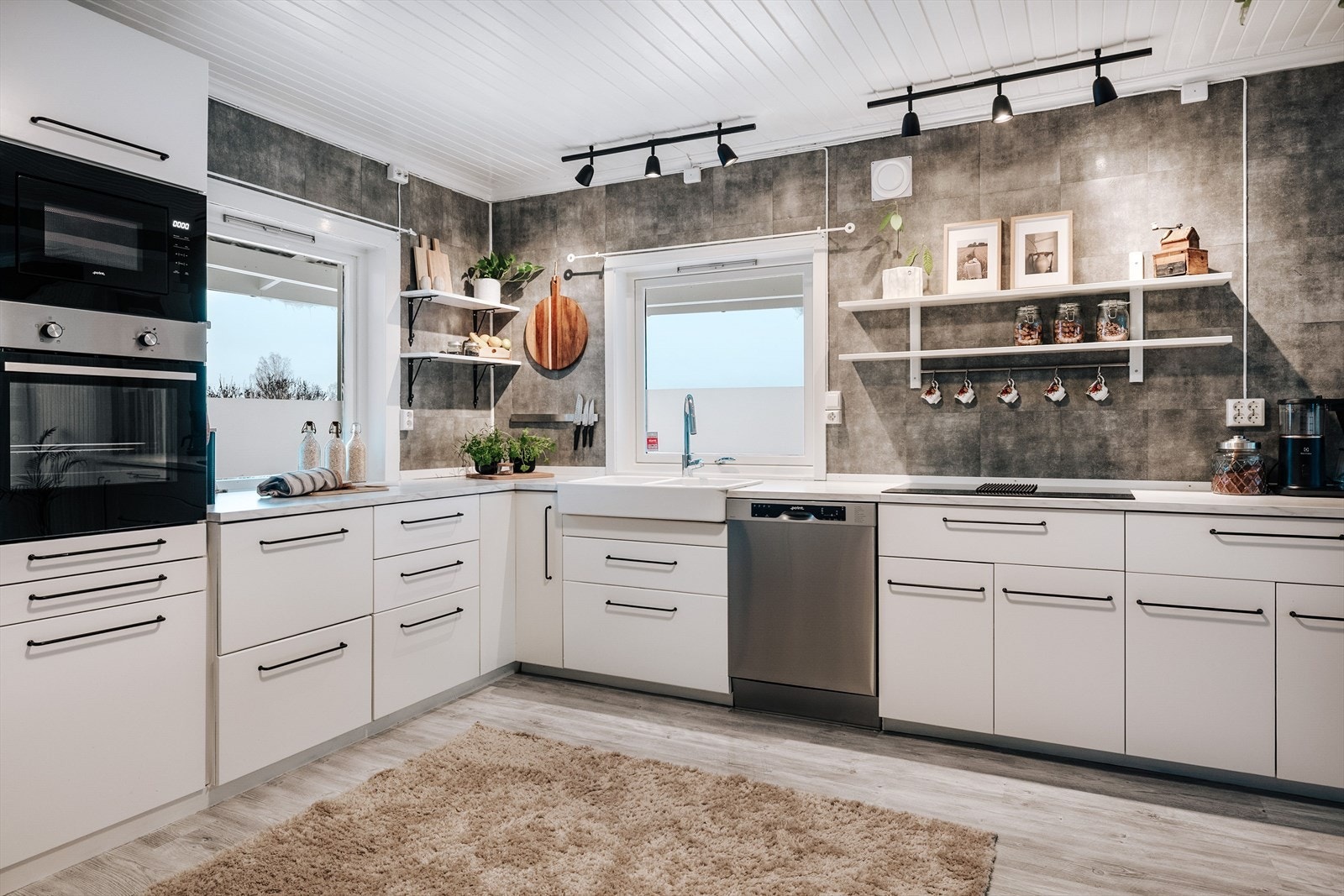 Kjøkkenet har underskap og veggskap med hvite, glatte fronter. Laminert benkeplate med nedfelt dobbel utslagsvask. Galleribilde