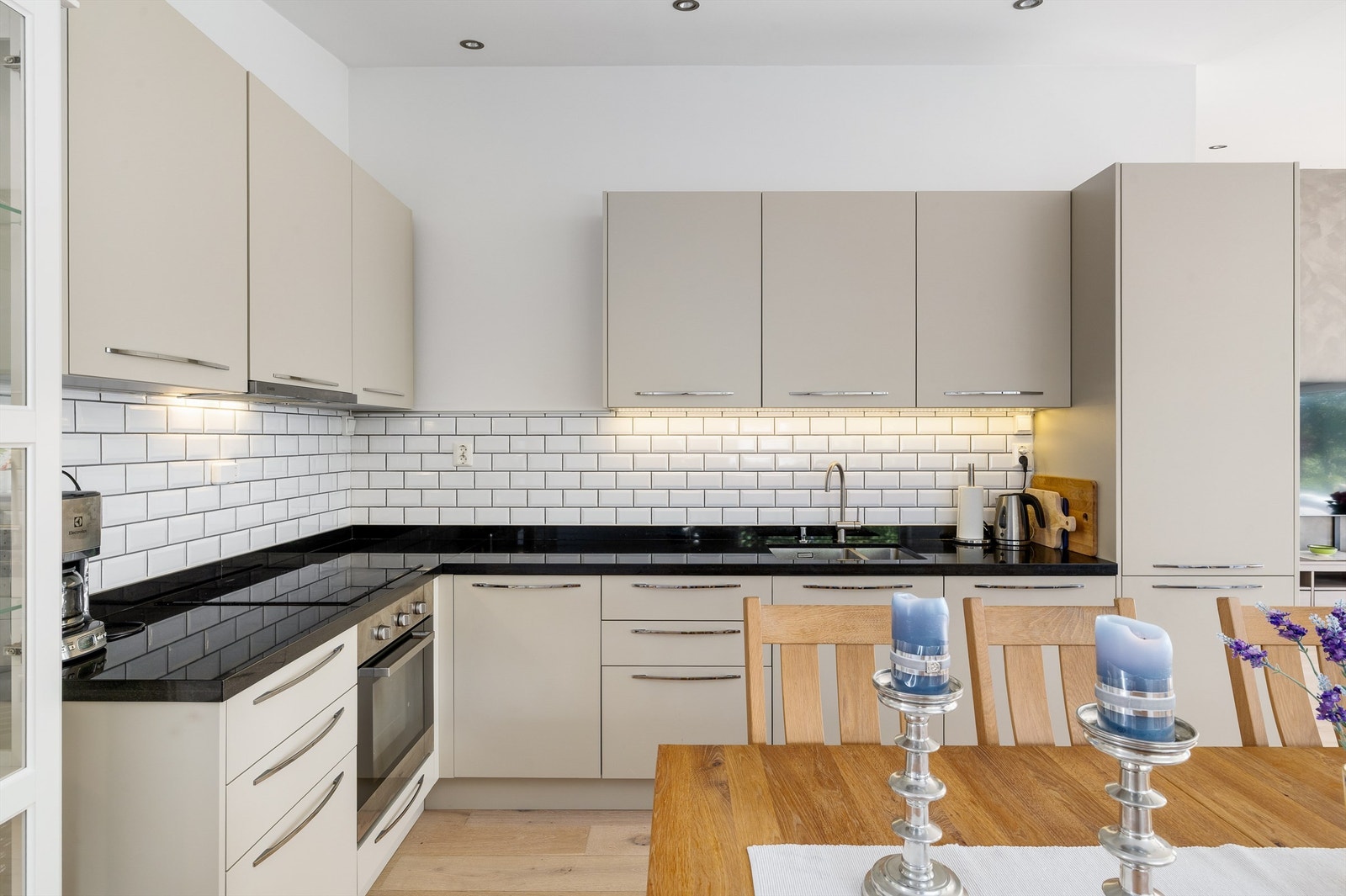 Kjøkkeninnredningen har slette fronter og metroflis mellom benk og overskap. Benkeplaten av slipt stein. Galleribilde