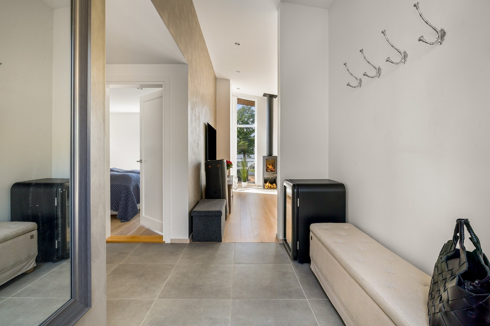 GLIMRENDE LØSNING: Fra utsiden kommer man rett inn i gangen, der det kort vei til toalettet. Med flislagt gang og bad er det lov å gå på do med sko på bena. Galleribilde