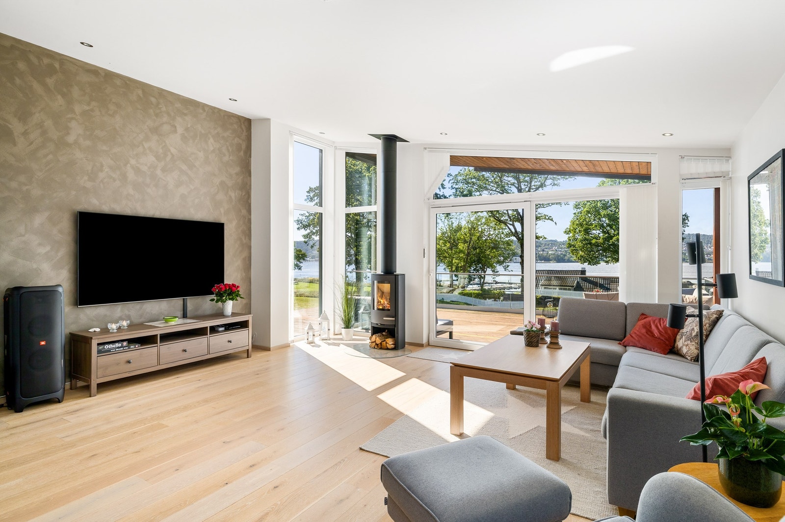 Sofakroken er plassert ut mot terrassen. De store vindusflatene gir godt lys. Fondveggen er malt med sjatteringer, et kult interiørinnslag. Galleribilde