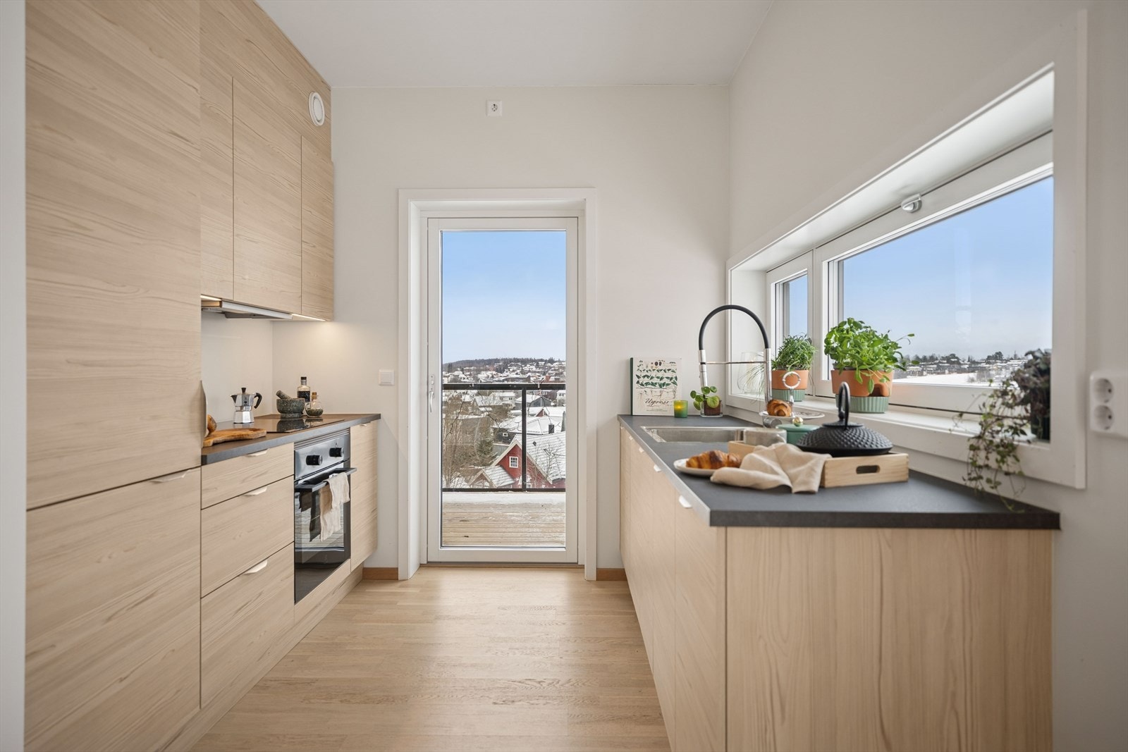 Kjøkkenet har laminerte benkeplater og god arbeidsplass under det brede vinduet. Galleribilde