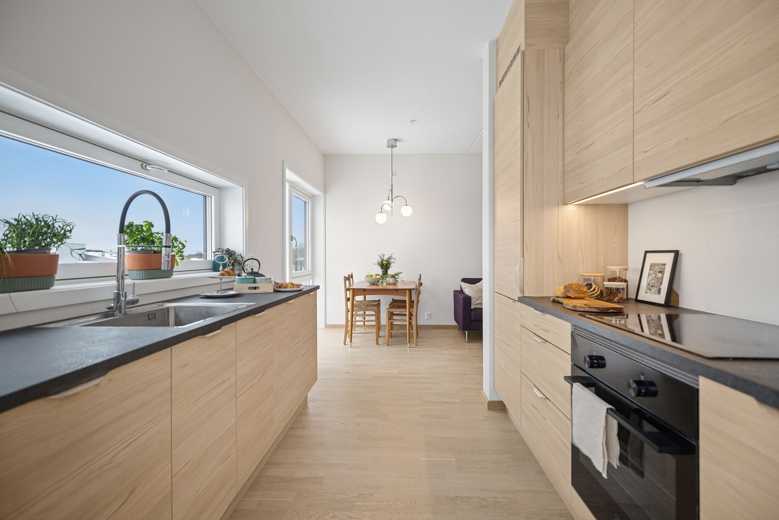 Lys under overskapene gir god belysning på kjøkkenbenken. Åpen løsning mot stuen. Galleribilde