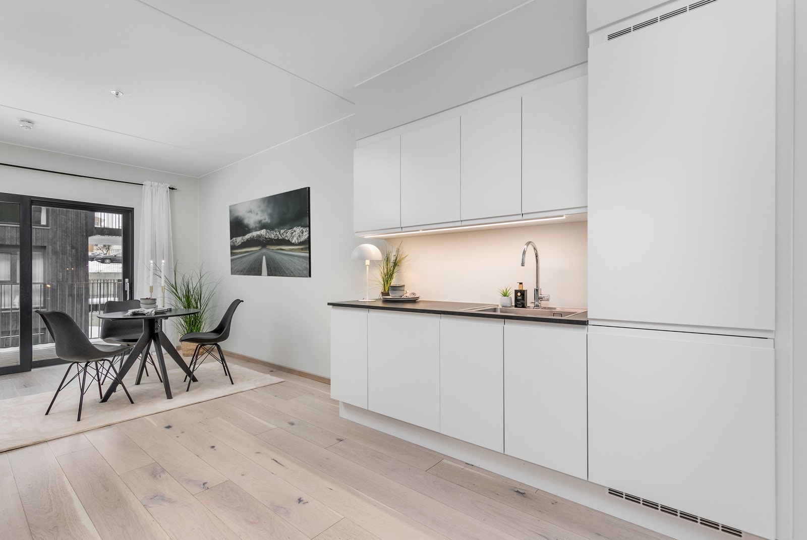 Stilrent og moderne kjøkken fra 2023 i åpen løsning mot stuen. Kjøkkenet har rikelig med skap og benkeplass. Kjøkkenet har lyse grepsfrie fronter. Galleribilde