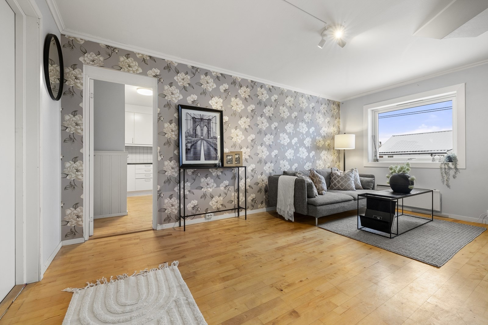 På veggene er det tapet og malte flater, mens gulvet har parkett som strekker seg inn i resterende rom. Galleribilde