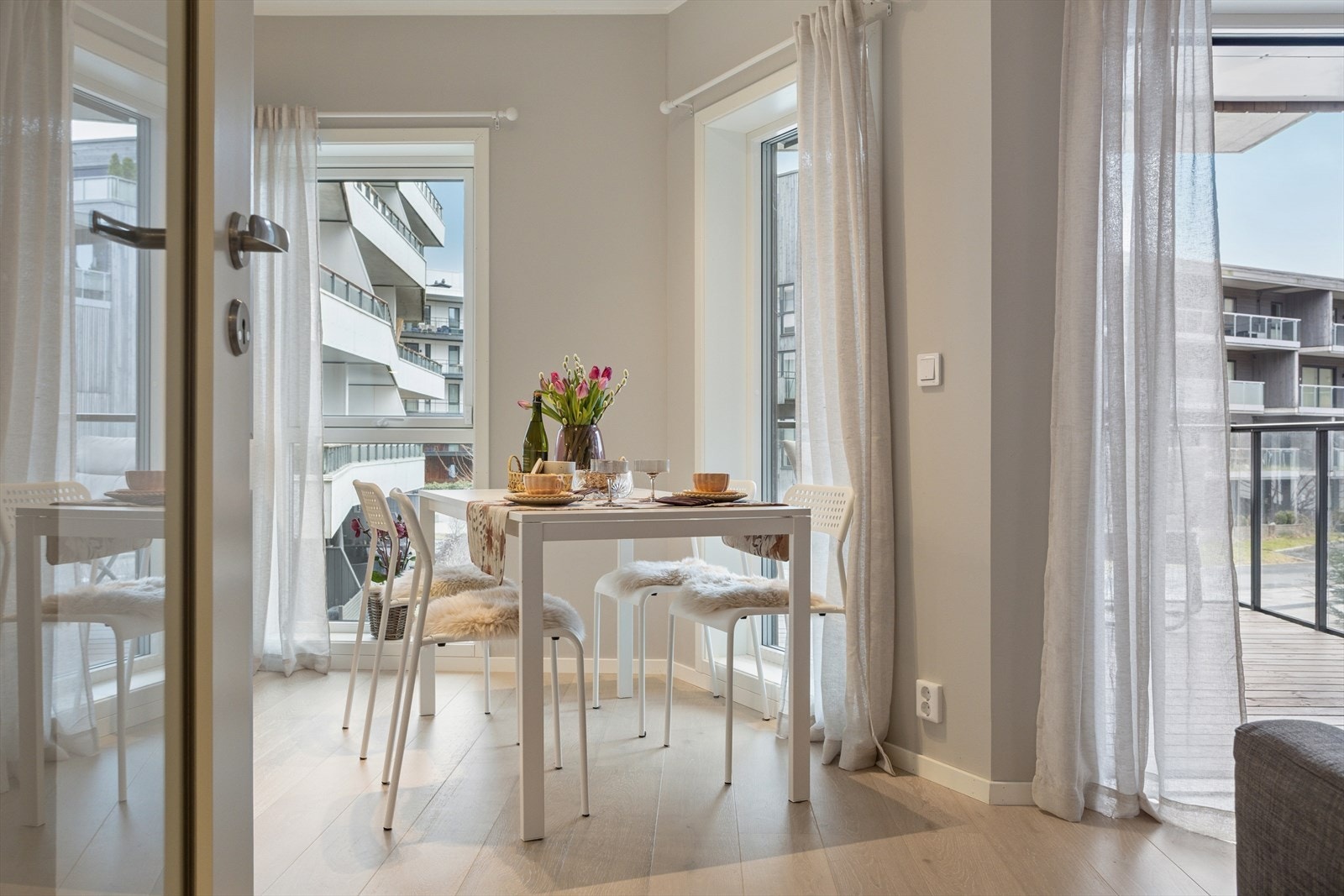 De store vindusflatene slipper inn rikelig med dagslys og fremhever rommets gode atmosfære, mens den åpne planløsningen mot kjøkkenet gir en naturlig flyt som gjør rommet både sosialt og funksjonelt. Galleribilde