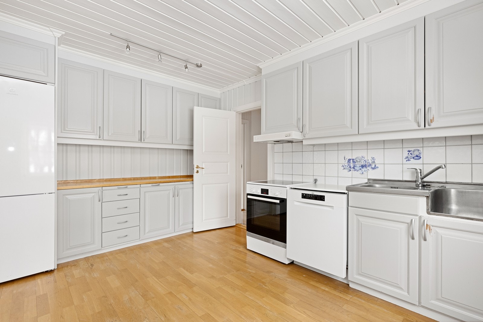 Kjøkkenet i 1. etasje har eldre innredning med profilerte, malte fronter og benkeplate i tre. Galleribilde