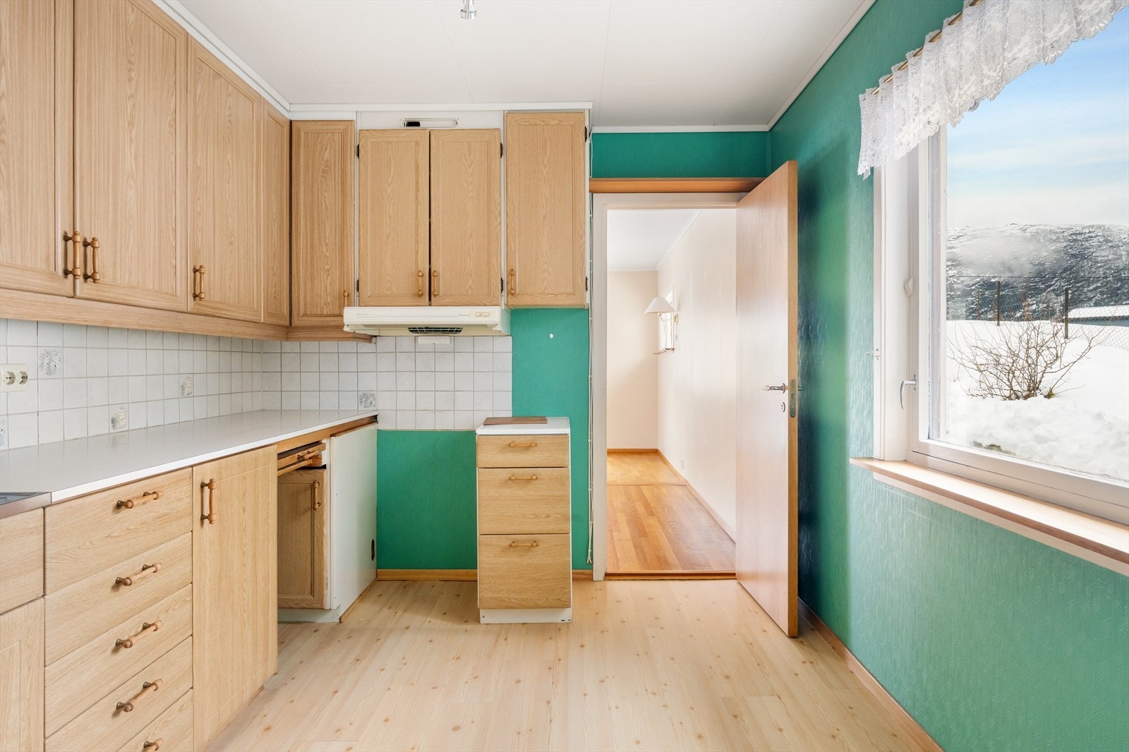 Kjøkkeninnredning med profilerte fronter og fliser på vegg over laminert benkeplate. Oppvaskmaskin er med i innredningen Galleribilde