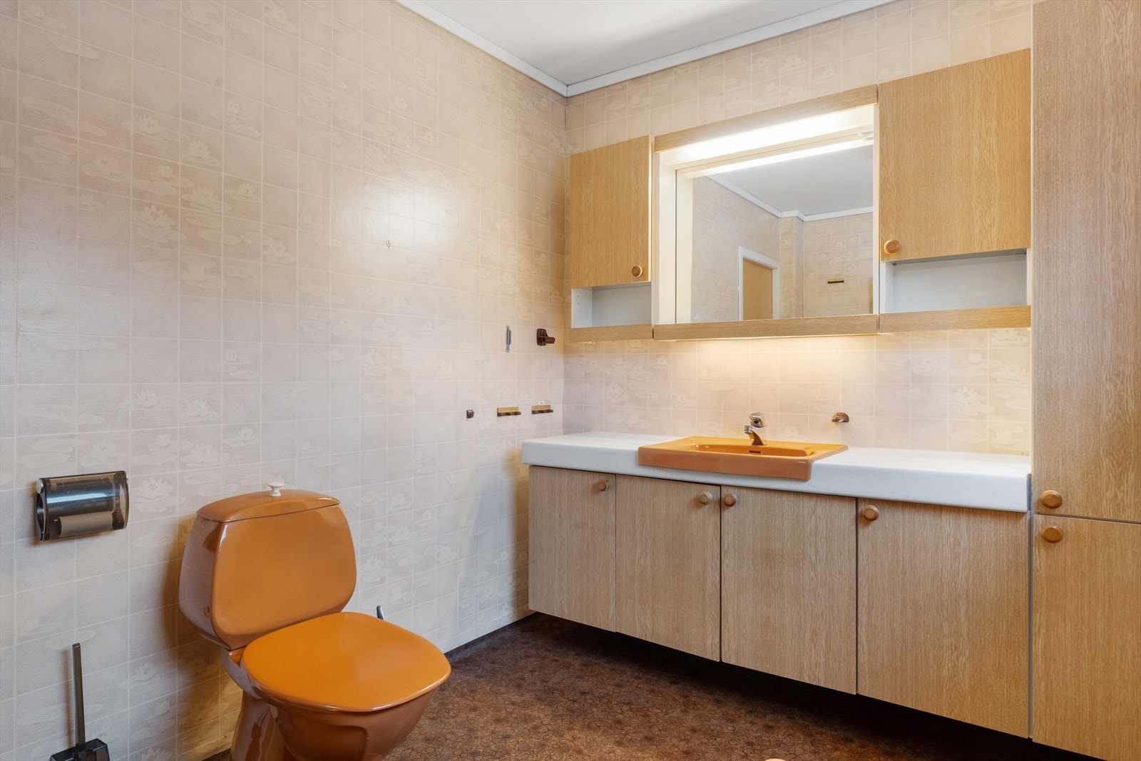 Bad innredet med servant i møbel, toalett og badekar. Galleribilde