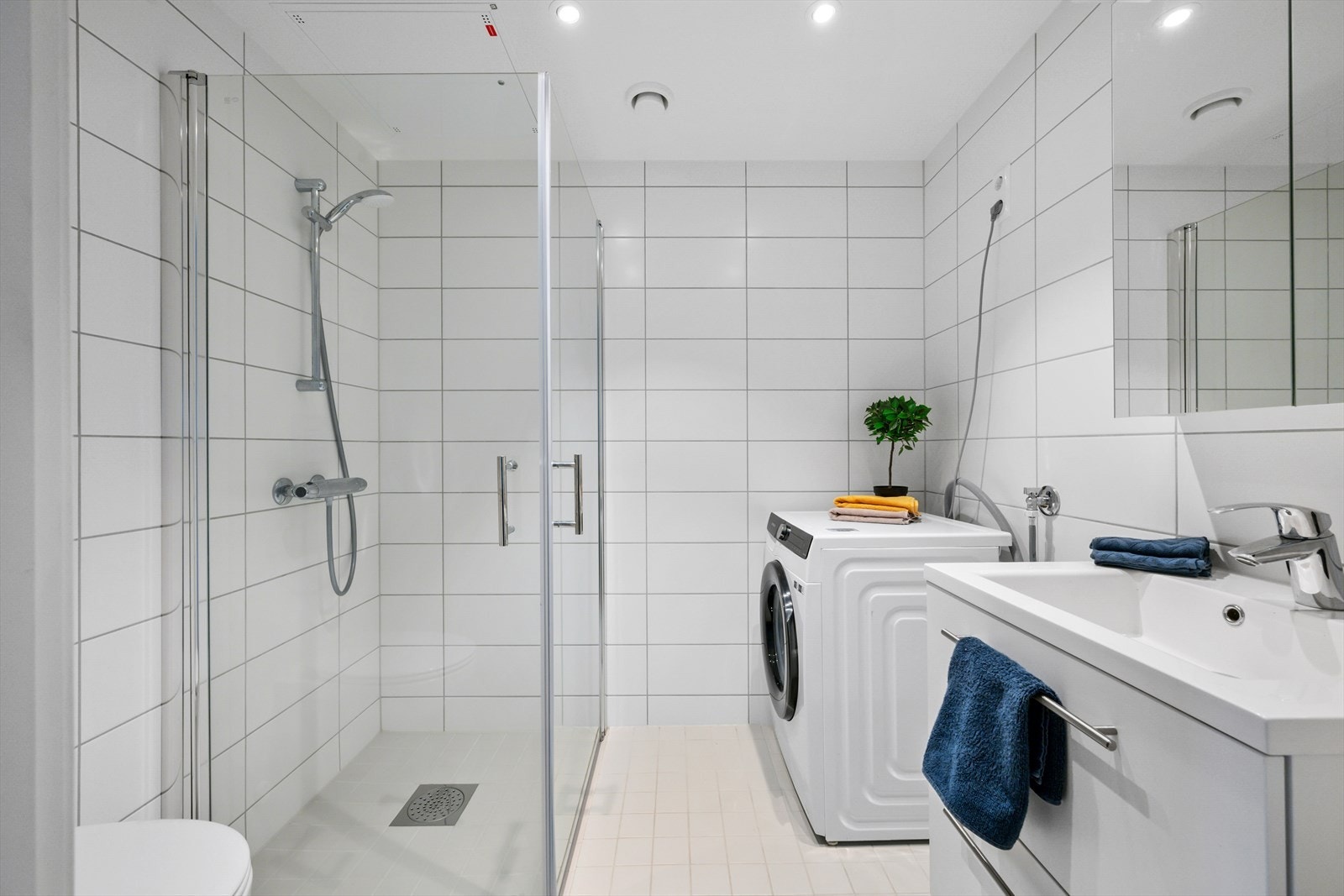 Lyst, pent bad med romslig dusjhjørne og plass for vaskemaskin og tørketrommel. Galleribilde