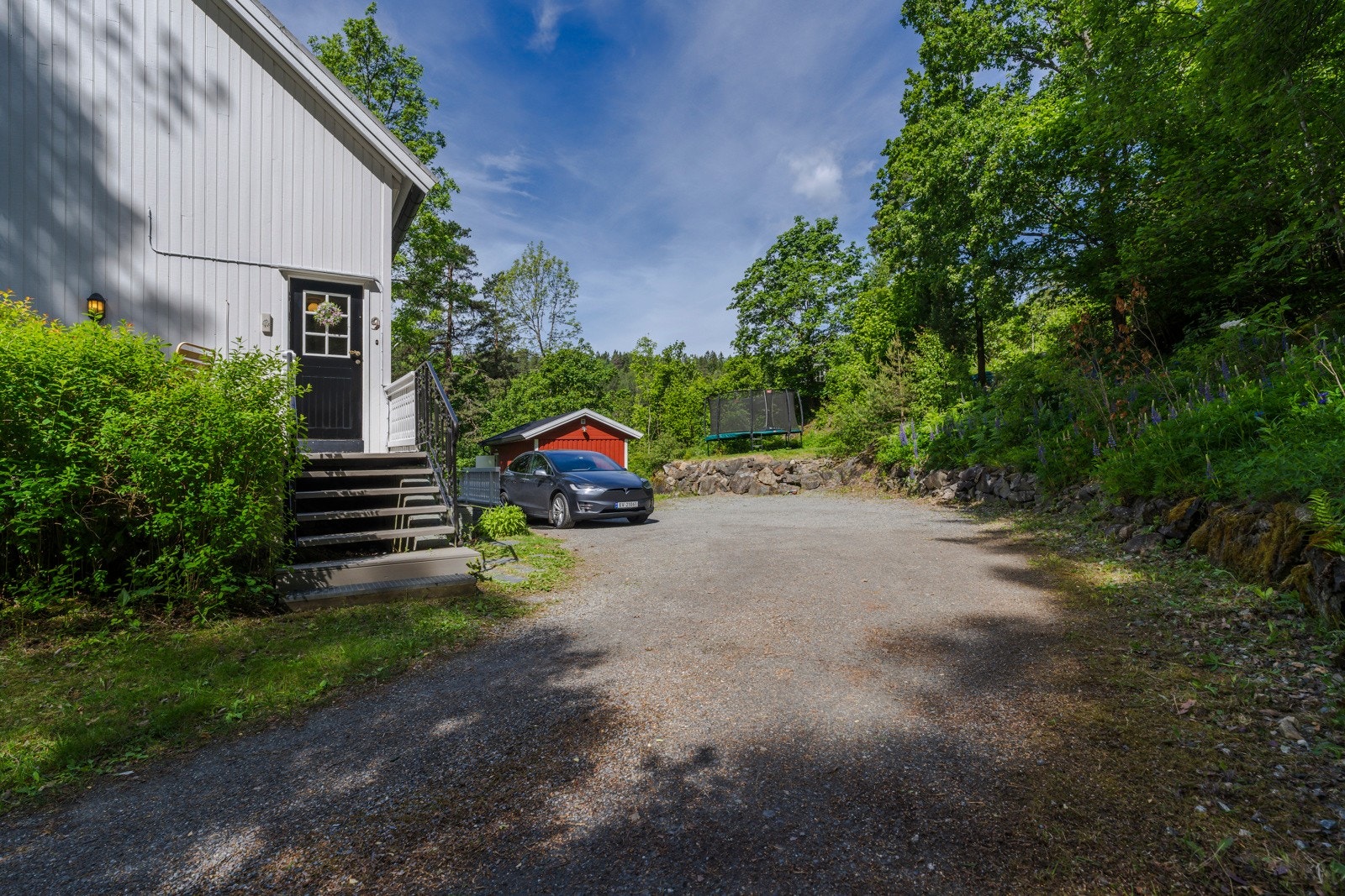 Eiendommen har god adkomst med gruset innkjørsel og rikelig med parkeringsplasser. Galleribilde