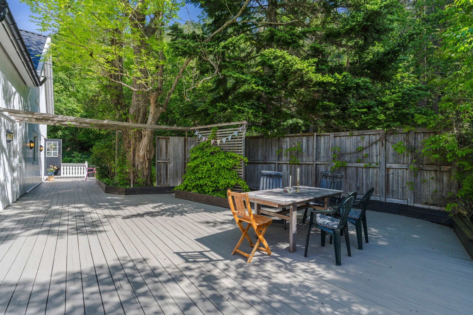 Boligen er omkranset av trær og vegetasjon, som skaper en lun atmosfære. Galleribilde