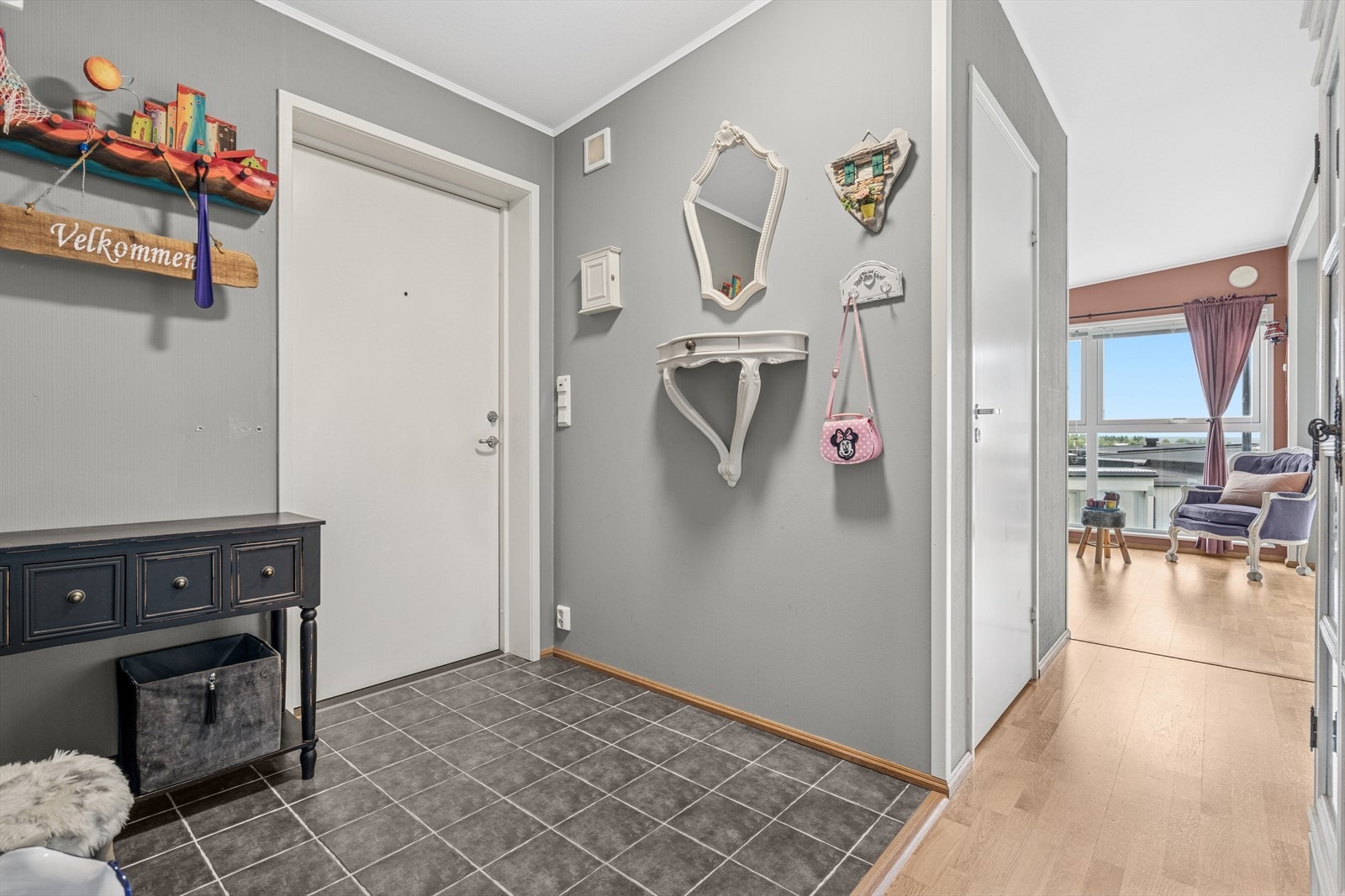 Man ønskes velkommen i en flislagt entré med plass til å henge fra seg yttertøy. Galleribilde