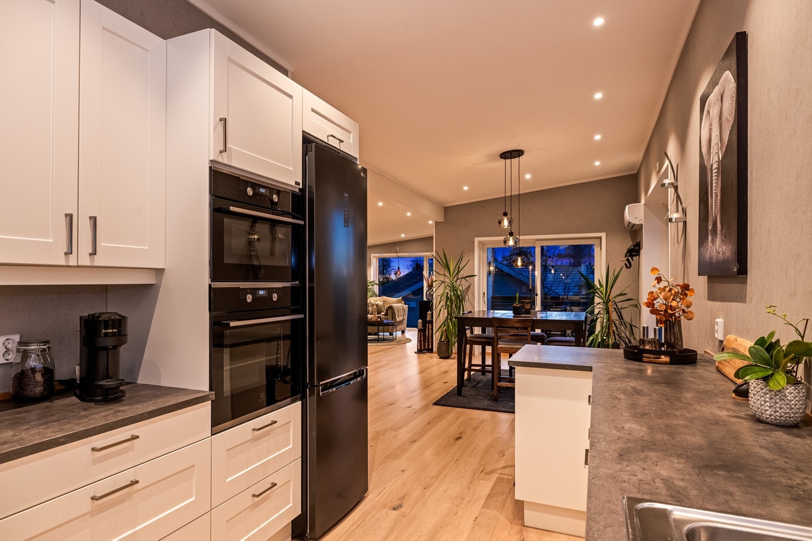 Integrerte hvitevarer, inkludert stekeovn og kjøleskap, gir en ryddig og funksjonell kjøkkensone. Galleribilde