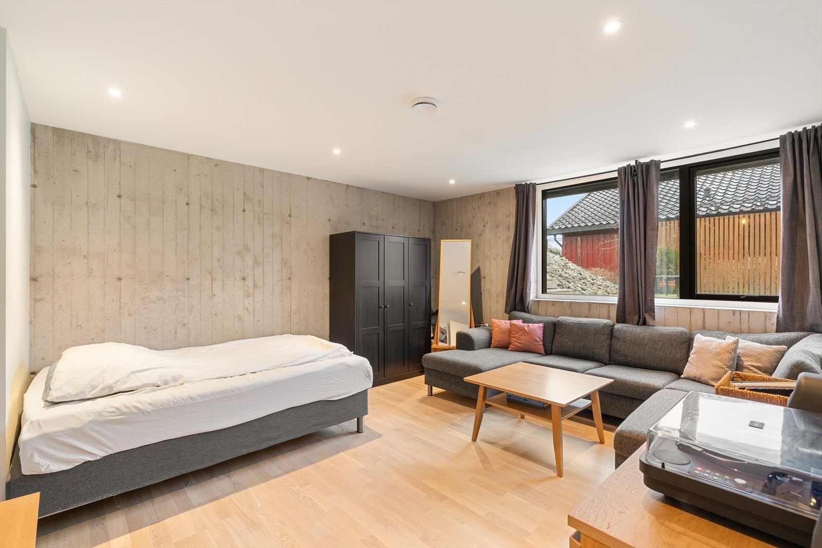 Soverom av god størrelse - stilige detaljer med betongvegger og sorte vinduer Galleribilde