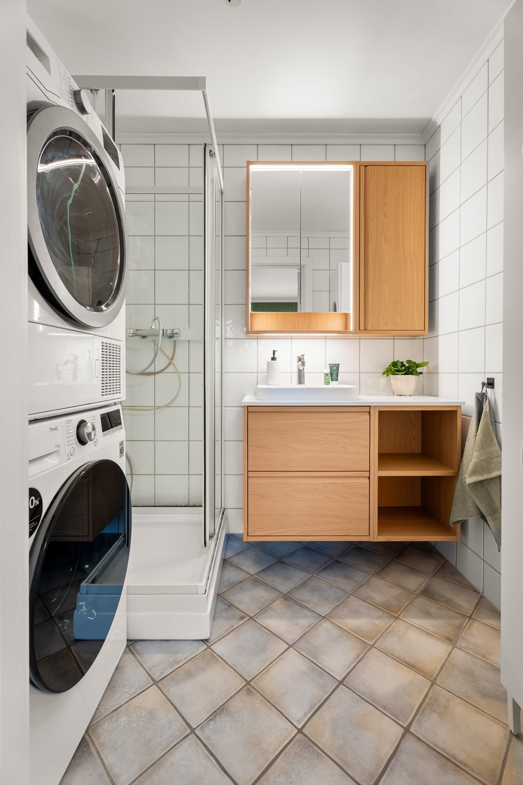 Badet er utstyrt med servantinnredning, speilskap med lys, dusjkabinett samt opplegg for vaskemaskin og tørketrommel. Galleribilde