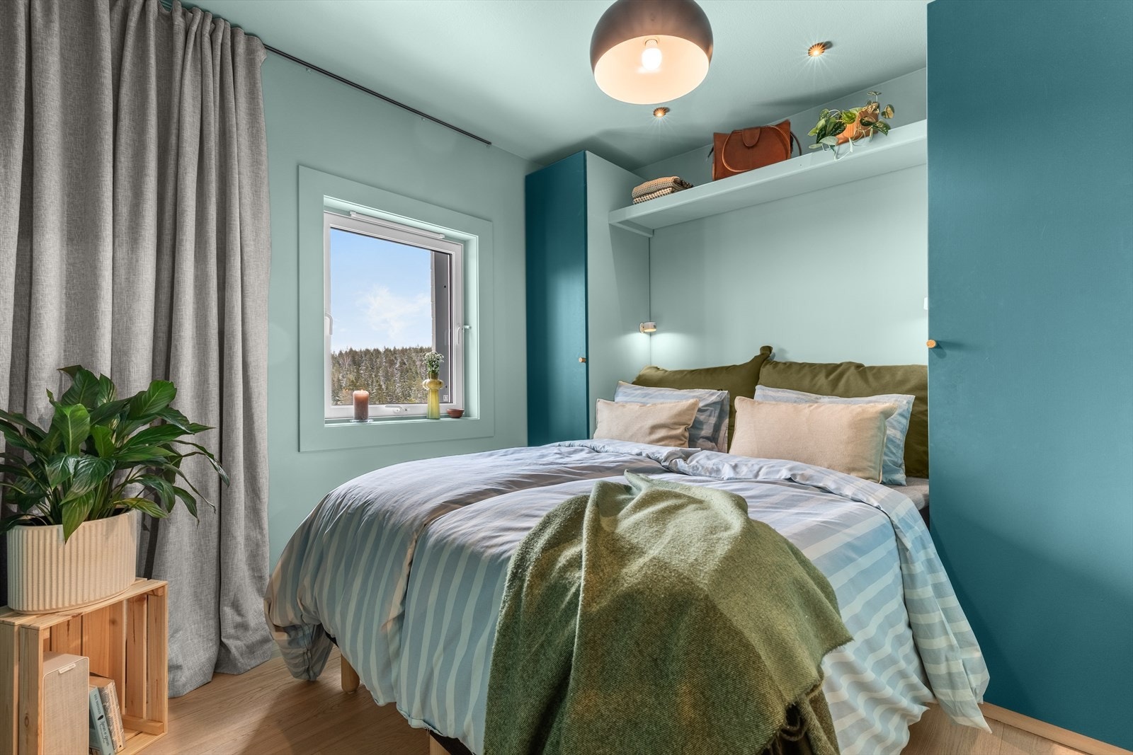 Hovedsoverommet preges av rolige blåtoner og god plass til dobbeltseng, mens det brede vinduet slipper inn rikelig med dagslys og gir et fint utsyn. Galleribilde