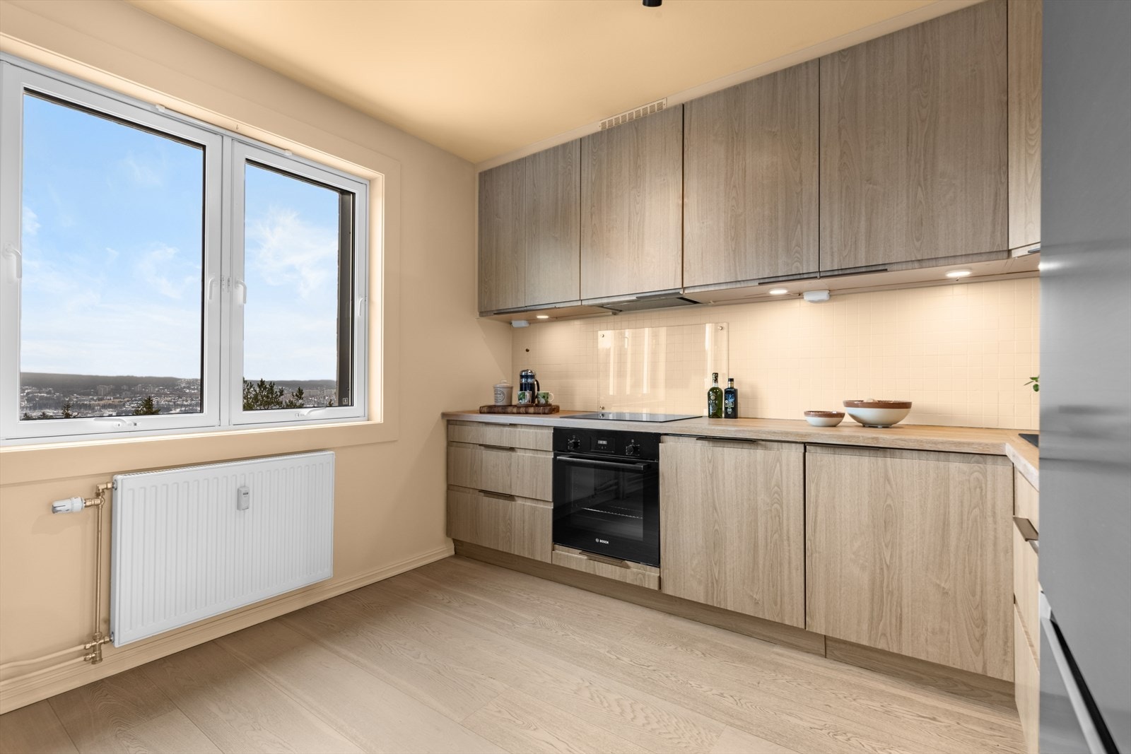 Innredningen har lyse, folierte fronter som ble oppgradert i 2025, samt en benkeplate i tre som gir rommet et varmt og rolig uttrykk Galleribilde