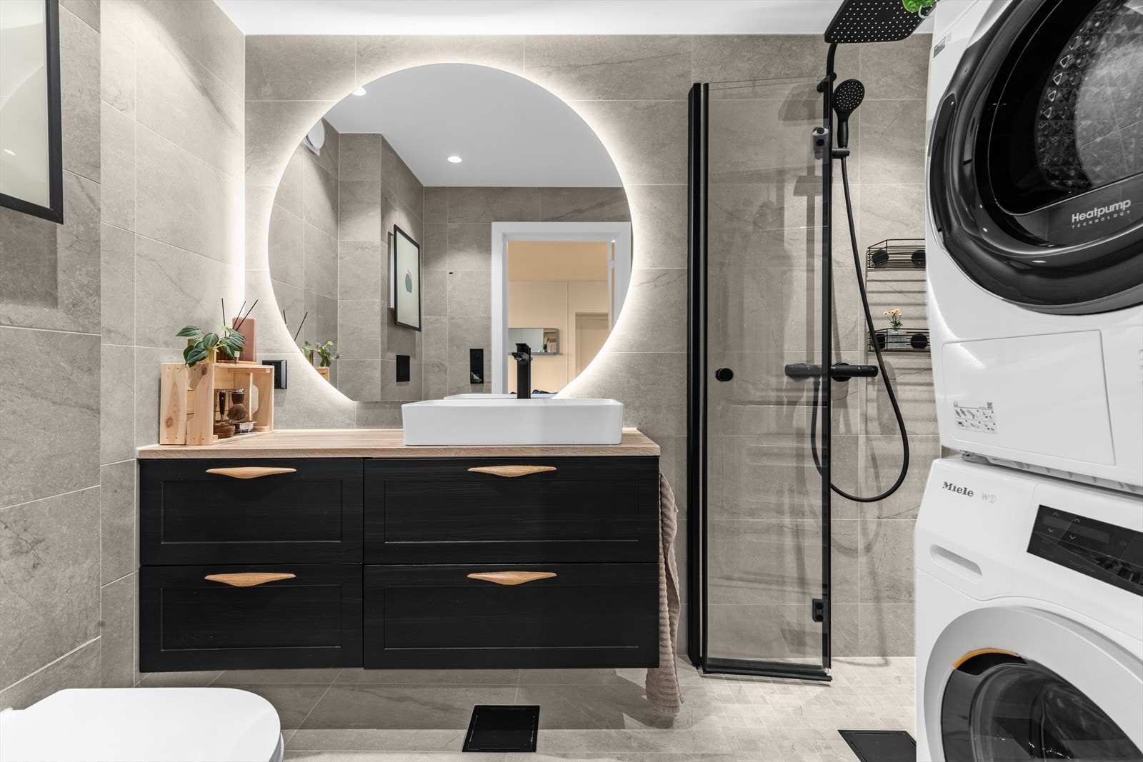 Badet ble totalrenovert i 2023 og fremstår som stilfullt og moderne. Store, tidløse fliser pryder både gulv og vegger, og er kombinert med gulvvarme og downlights som gir en behagelig belysning. Galleribilde