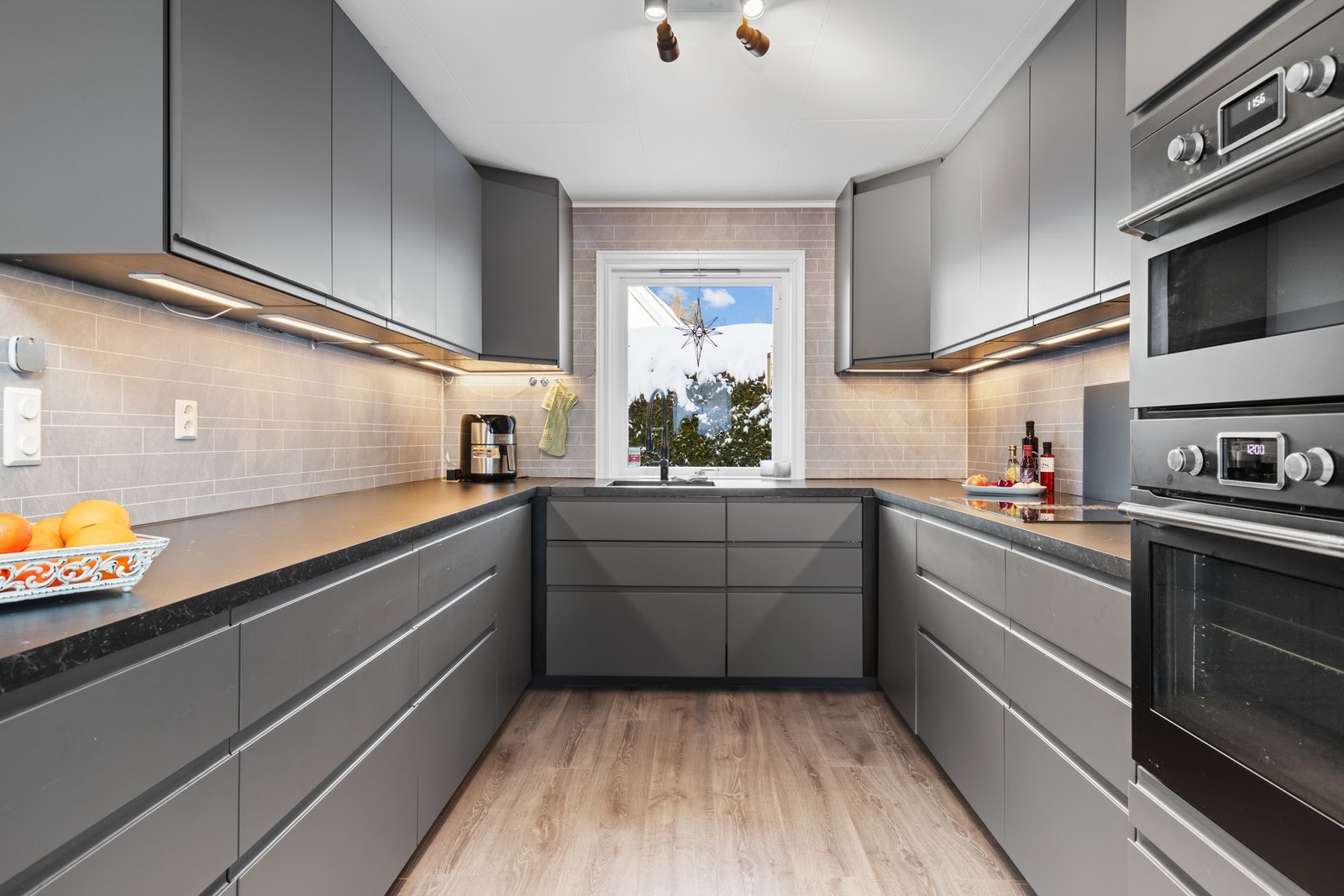 Romslig kjøkkeninnredning med god skap og benkeplass. Galleribilde