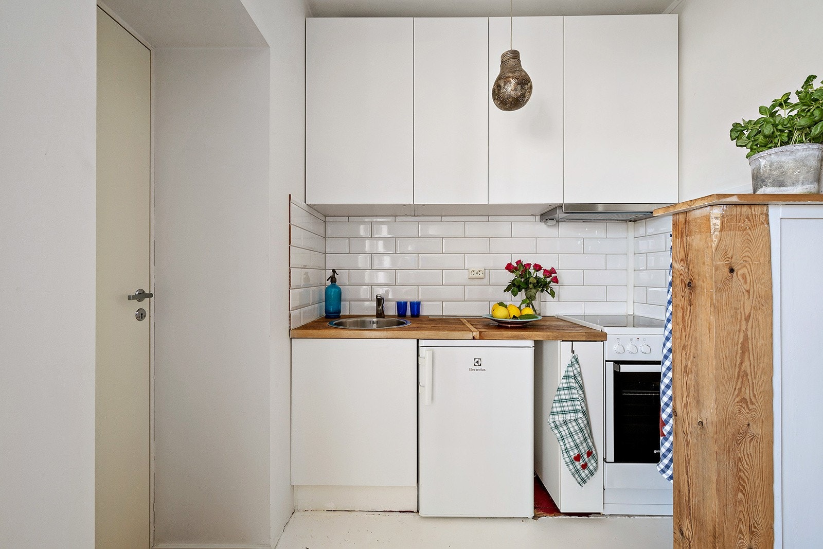 Moderne kjøkkeninnredning med hvite glatte fronter, benkeplate i tre Galleribilde