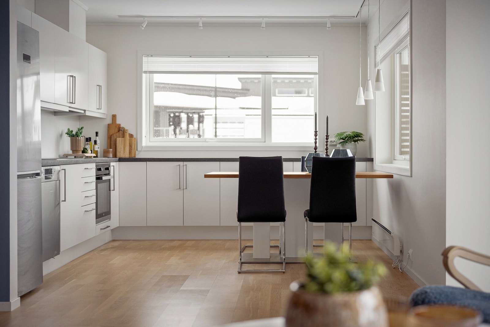 Det er naturlig plass til spisebord ved vinduene, og løsningen fungerer nærmest som en egen spisestue - et hyggelig og sosialt samlingspunkt i boligen med godt lysinnslipp. Galleribilde