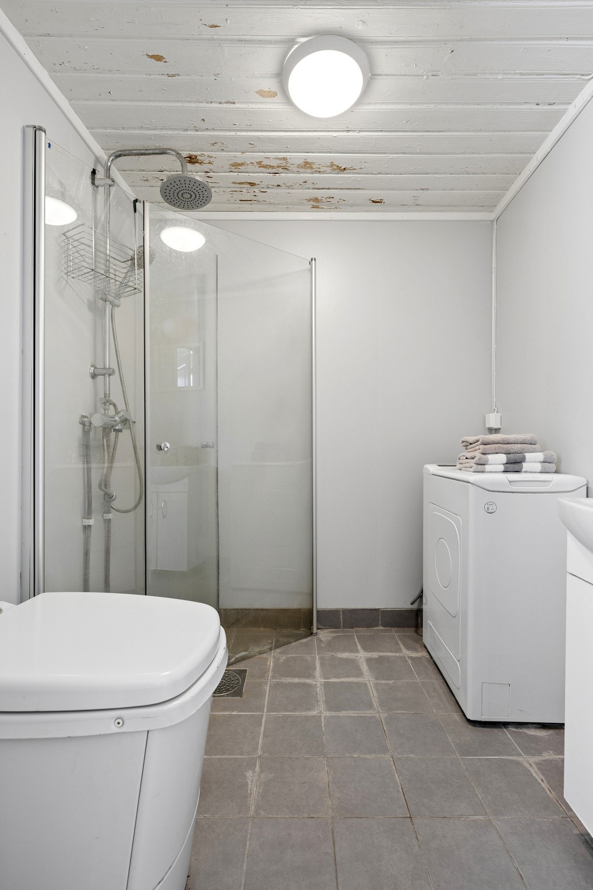 Badet er innredet med dusjhørne med glassdører, servant og forbrenningstoalett (Cinderella). Galleribilde