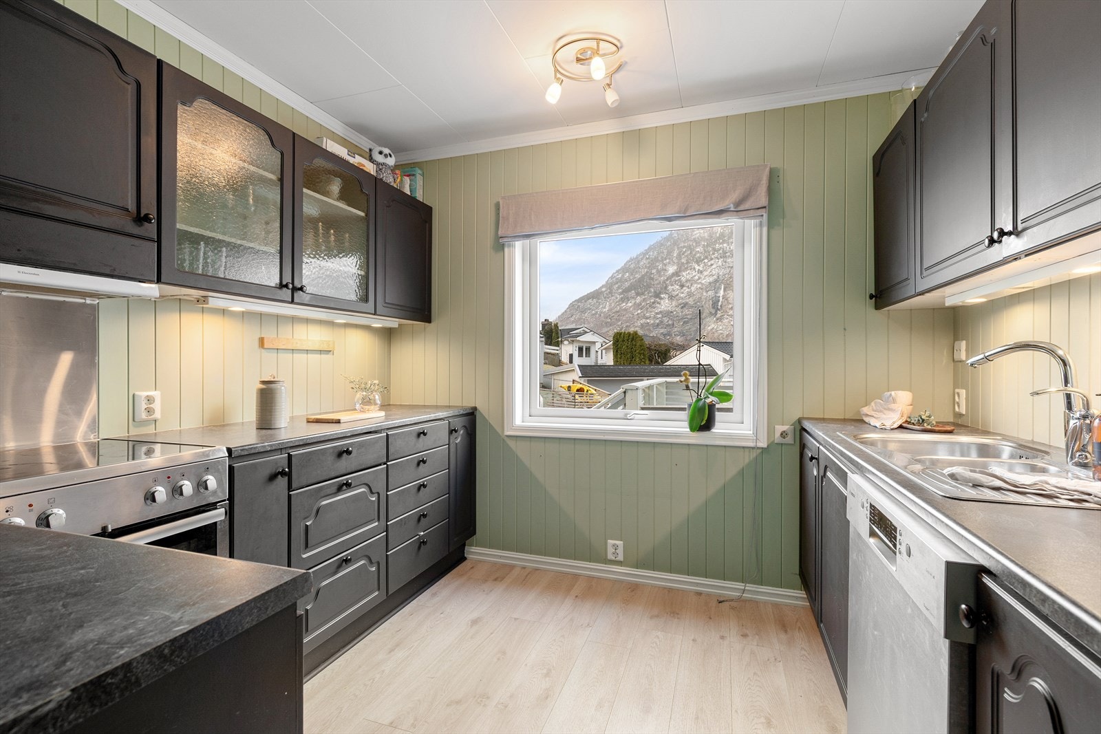 Kjøkkenet har malt kjøkkeninnreiing og benkeplate av laminat. Galleribilde