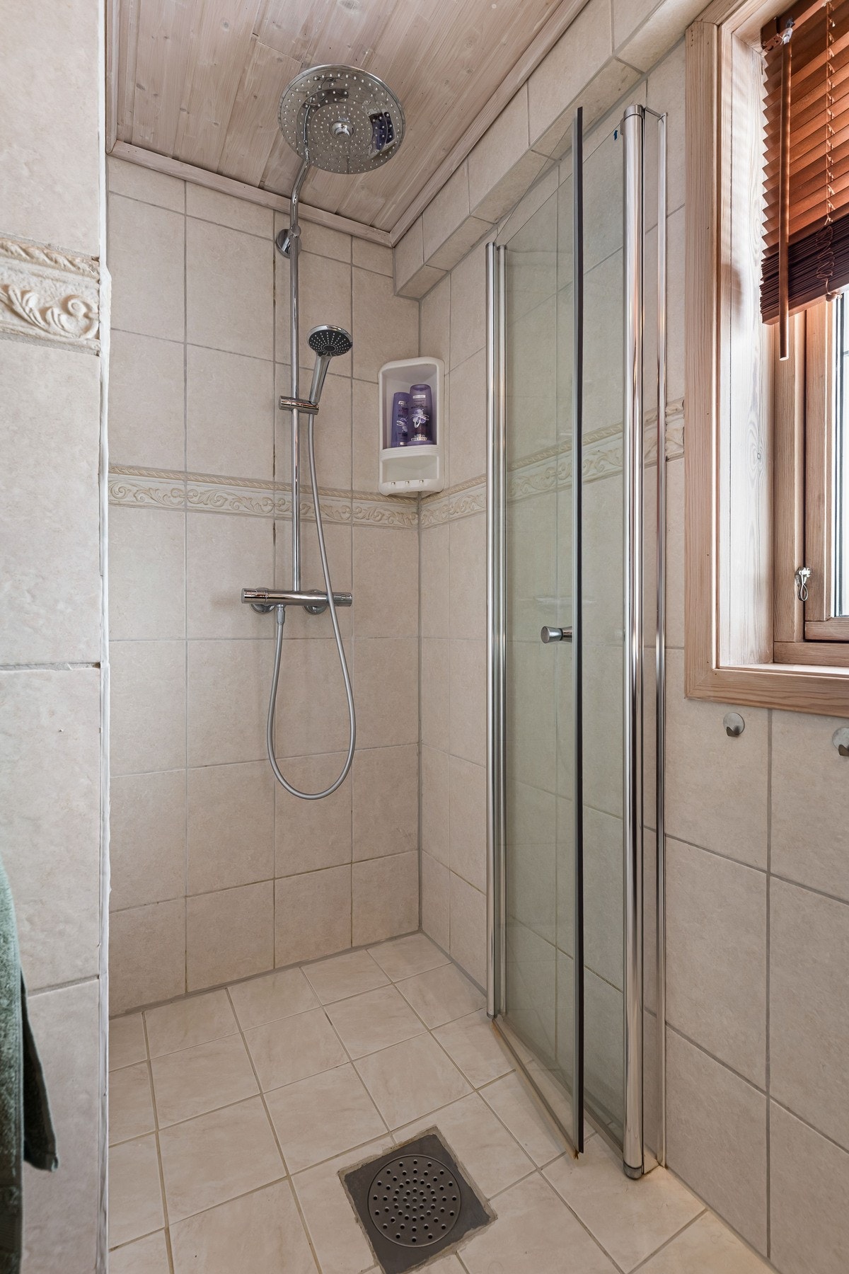 Delikat dusjnisje med regnfallsdusj og praktiske foldedører. Galleribilde