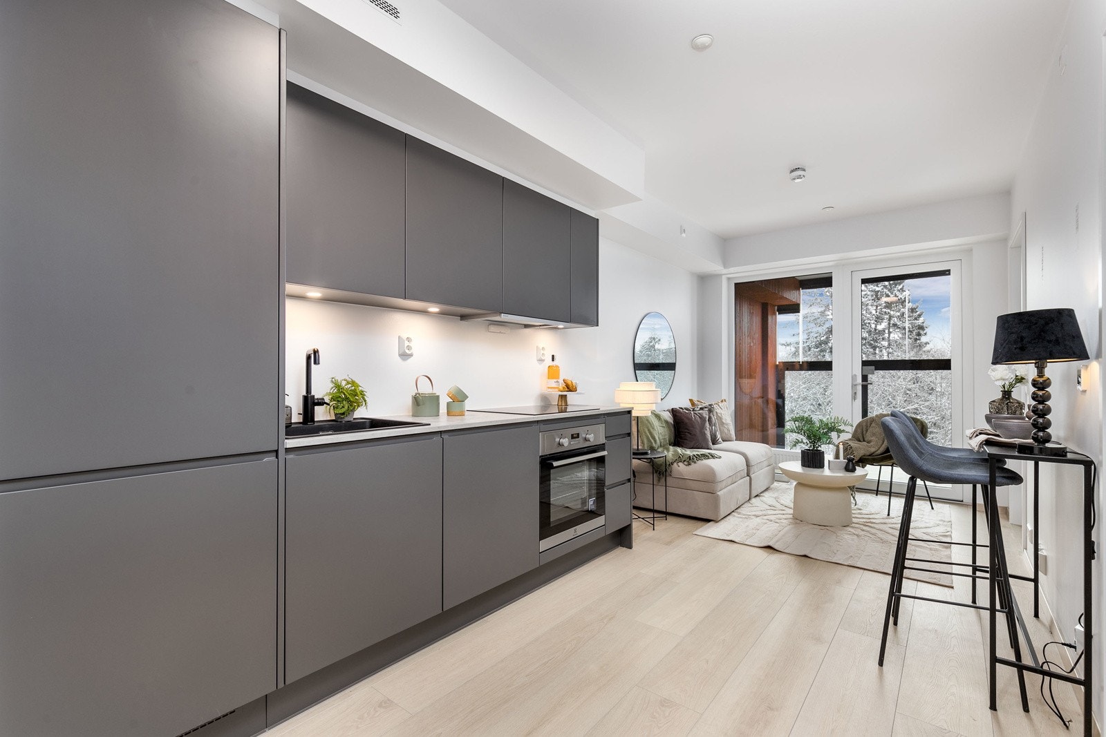 Lekkert kjøkken i åpen løsning mot stue, med integrerte hvitevarer. Galleribilde