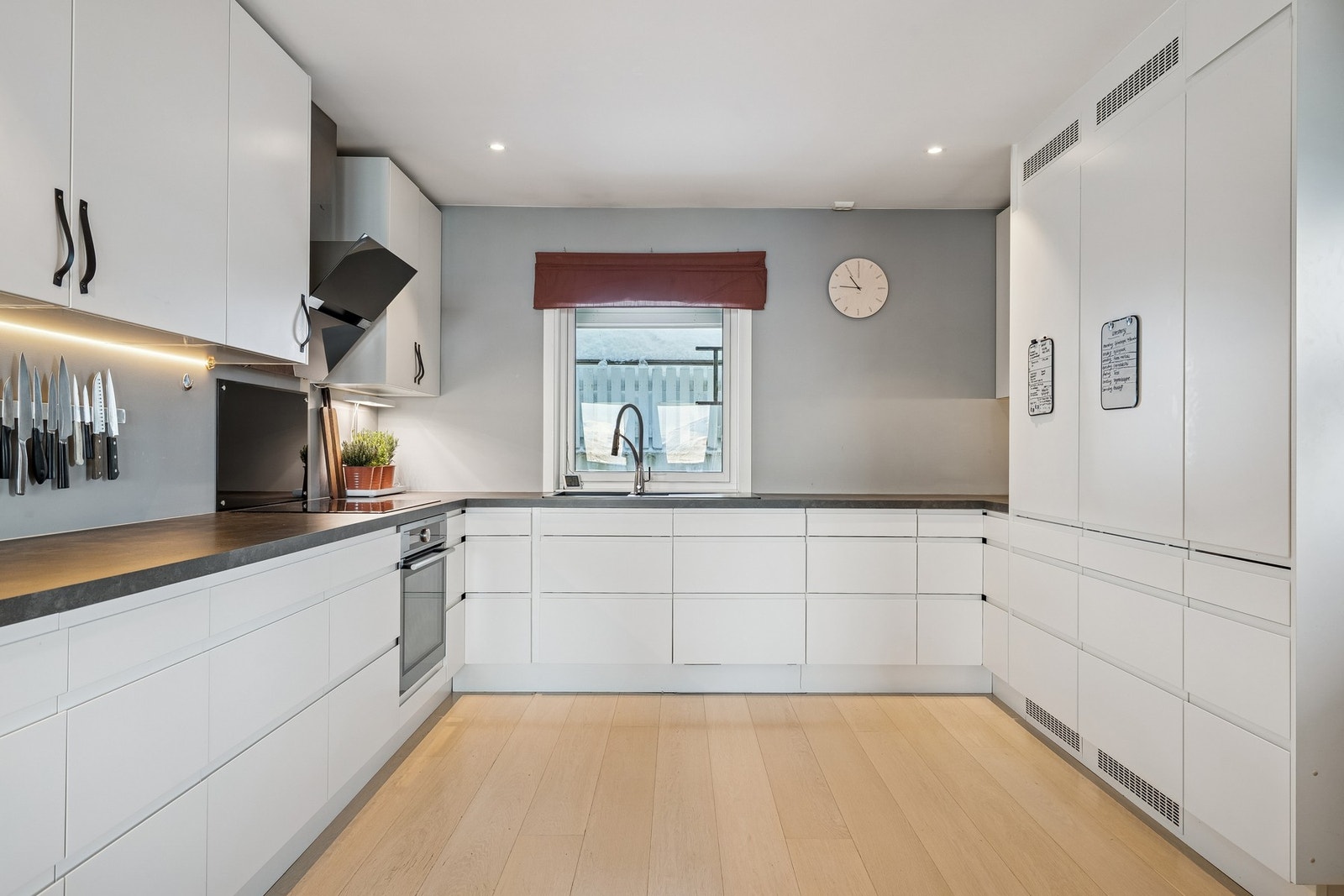 Hvitt klassisk kjøkken med stilrene integrerte hvitevarer Galleribilde