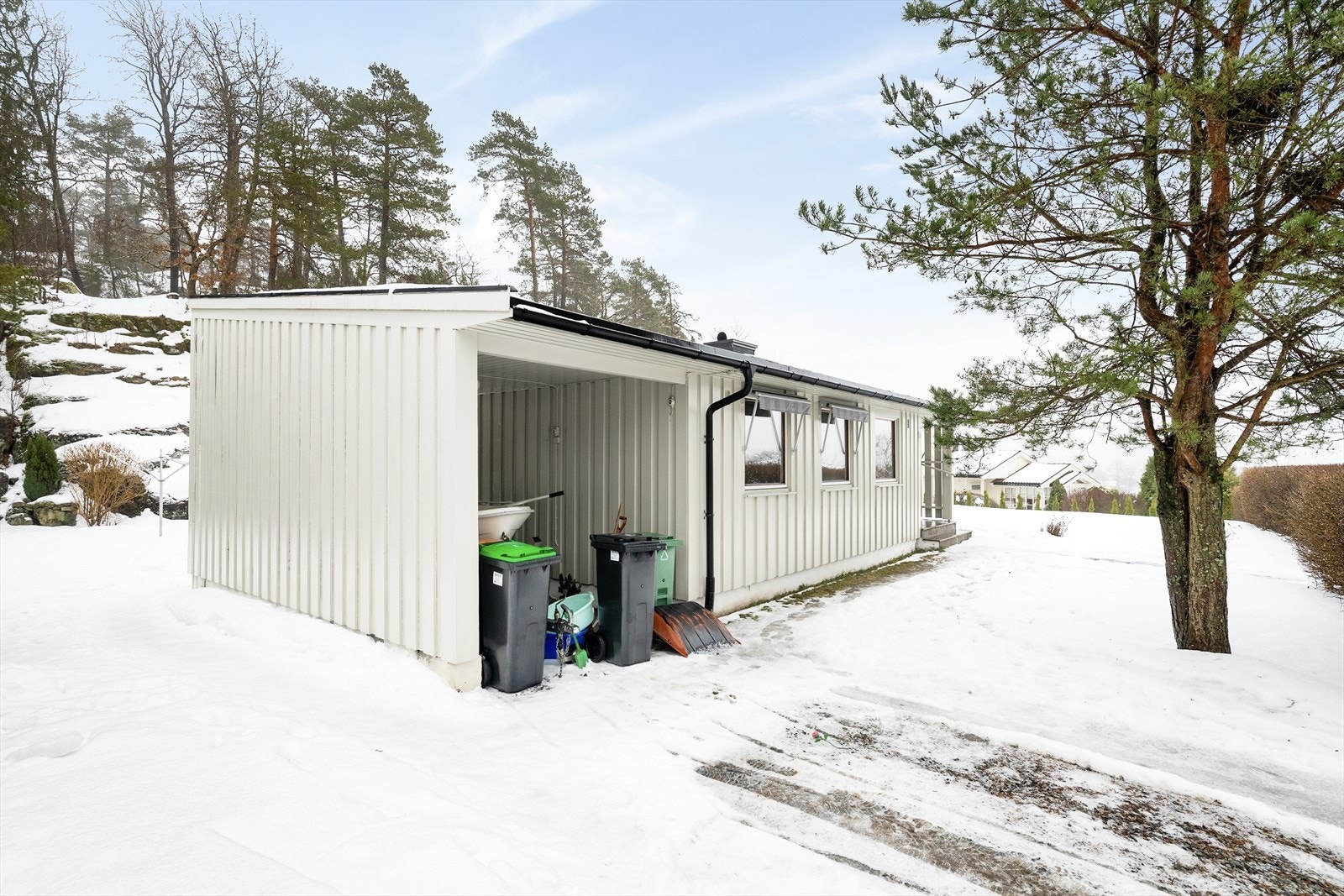 Mot gateplan er det gruset gårdsplass for biloppstilling, samt at det er carport tilliggende boligen på ca. 15 m2. Galleribilde