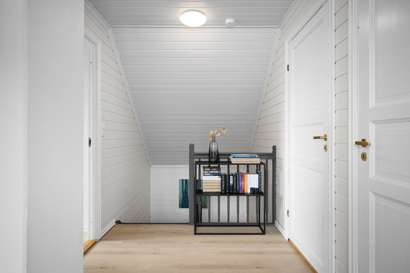 Trappen leder opp til en lys loftstue. Galleribilde