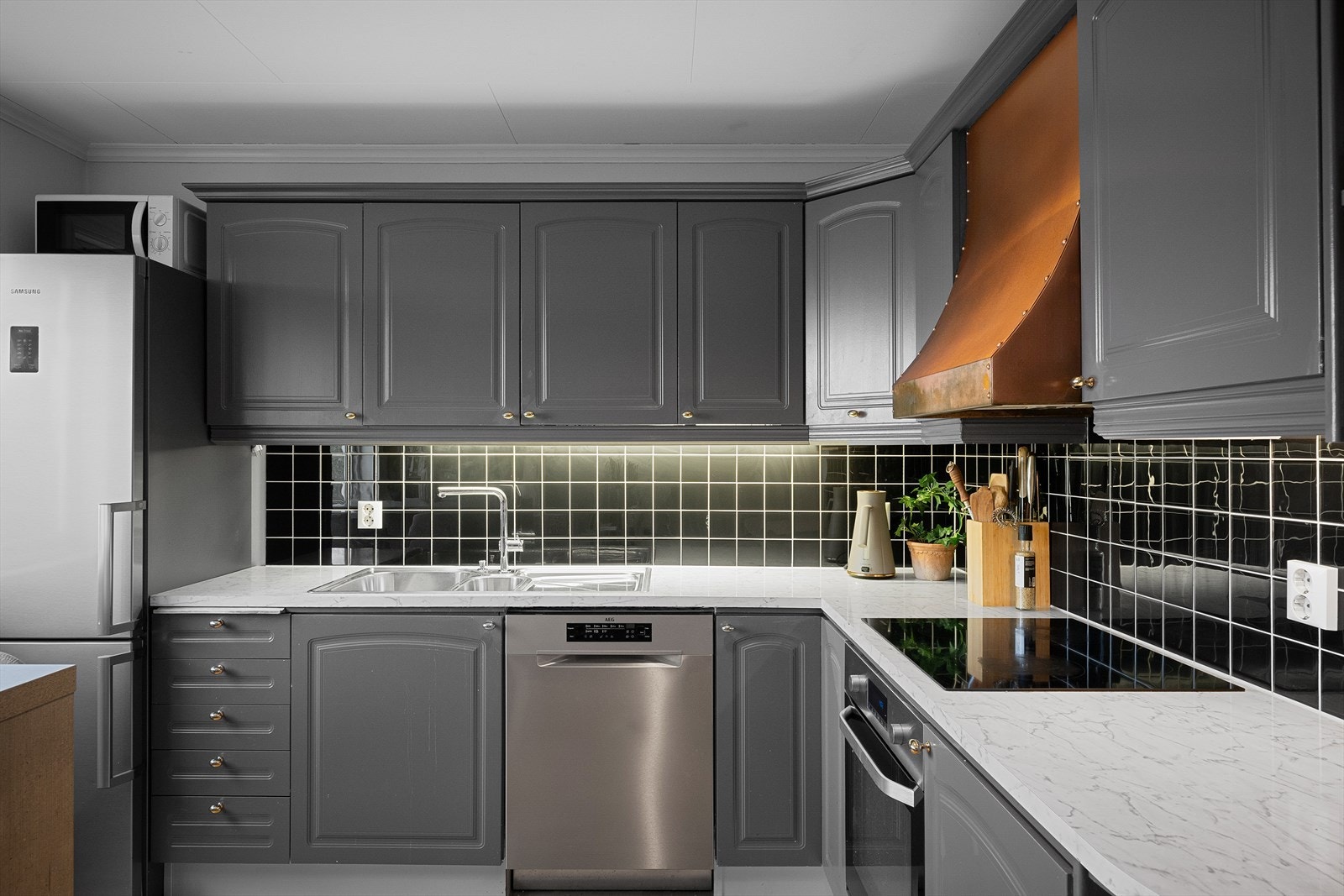 Innredningen er holdt i en moderne gråfarge med lys laminat benkeplate og god skapplass. Galleribilde