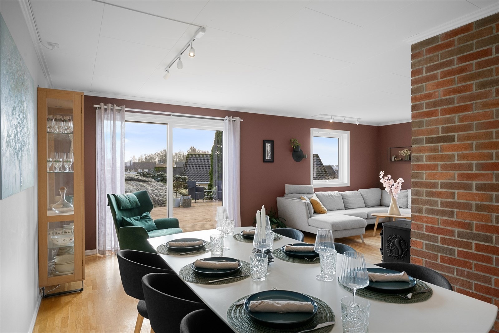 Fra spiseplassen ser man ut mot den store terrassen og hagen. Galleribilde