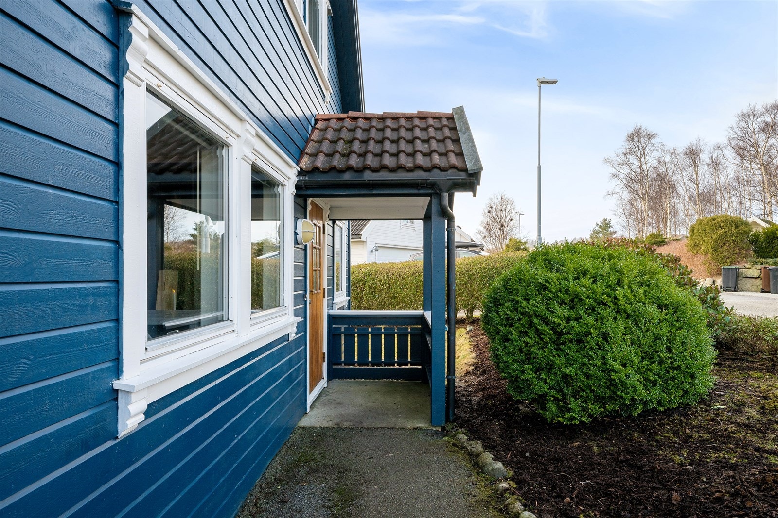 Overbygget inngangsparti med hoveddør i teak(nylig lakkert) fra byggeåret. Galleribilde